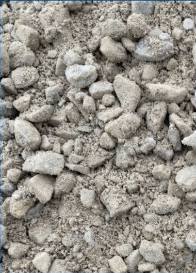 Close-up view of loose, uneven gravel or dirt with small rocks and particles.