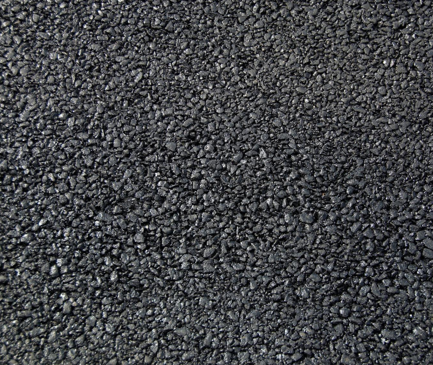 Close-up of black asphalt road surface with small gravel.