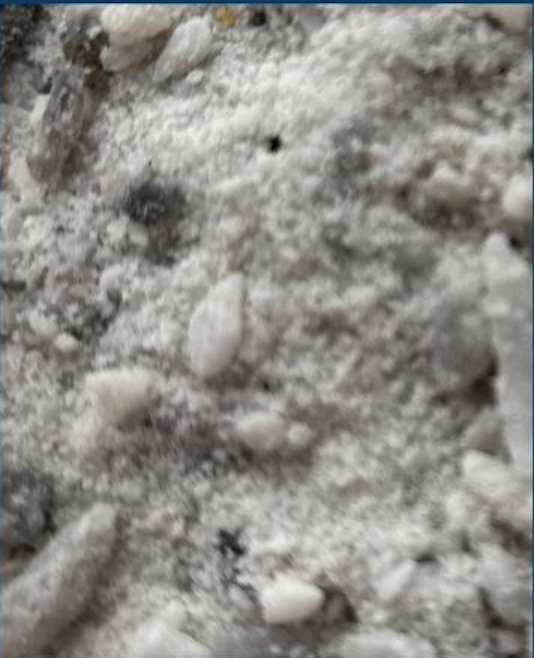 Close-up of a snowy and rocky ground surface.