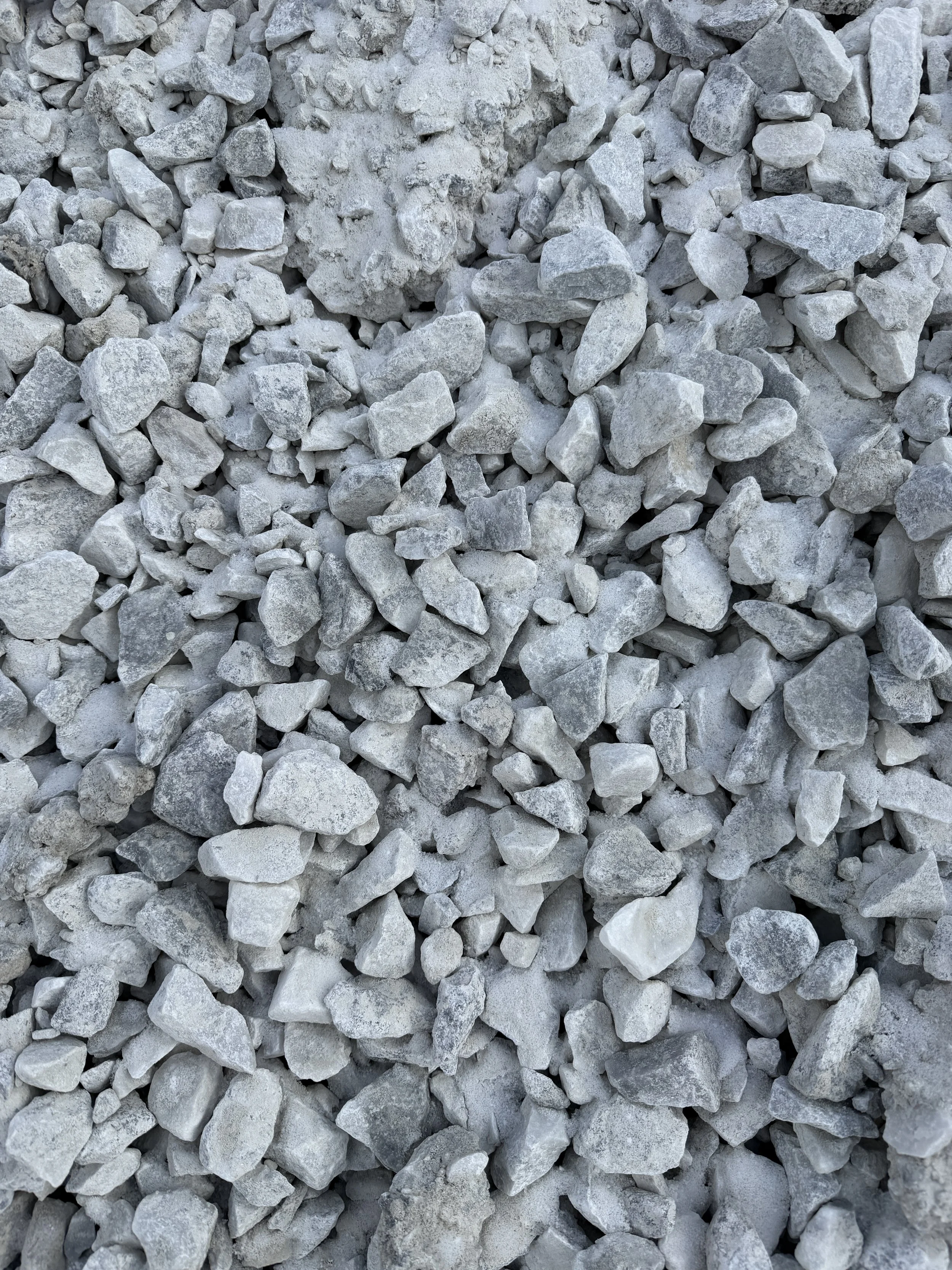 A close-up view of numerous irregularly shaped gray and white rocks or gravel.