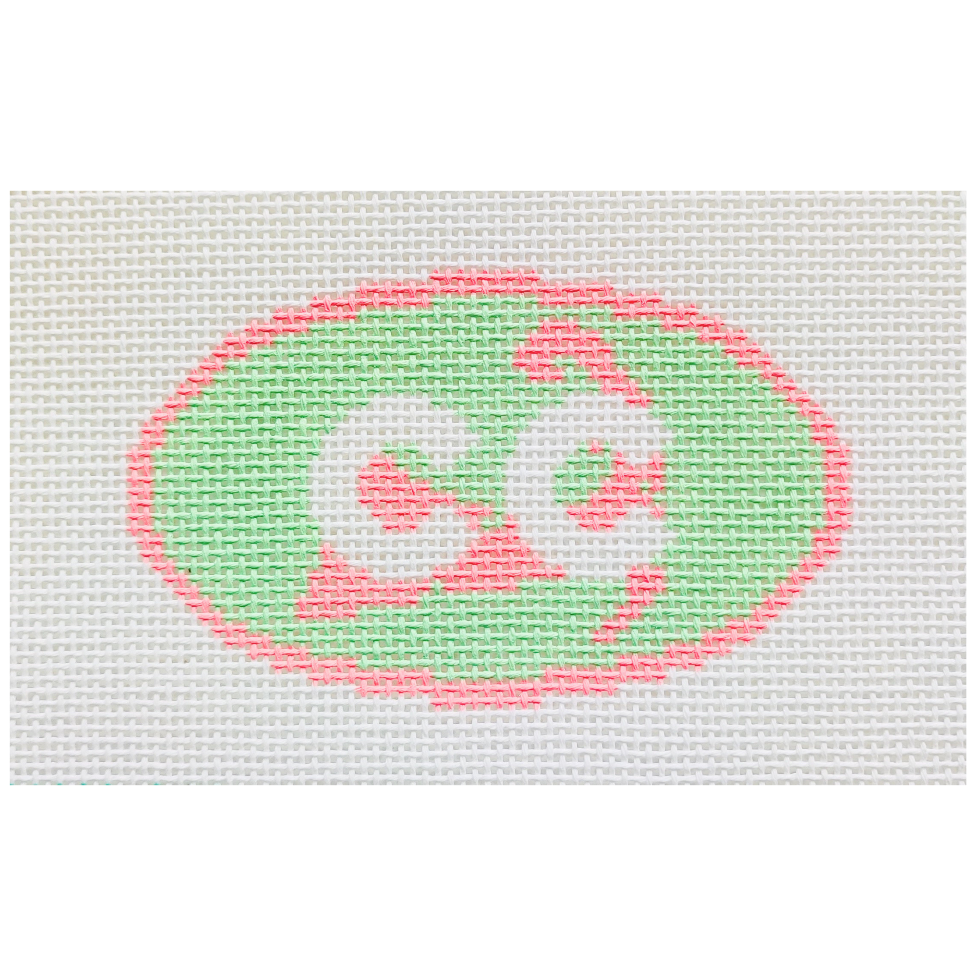 Needpoint design of a pink and green oval with the letters CC in white.
