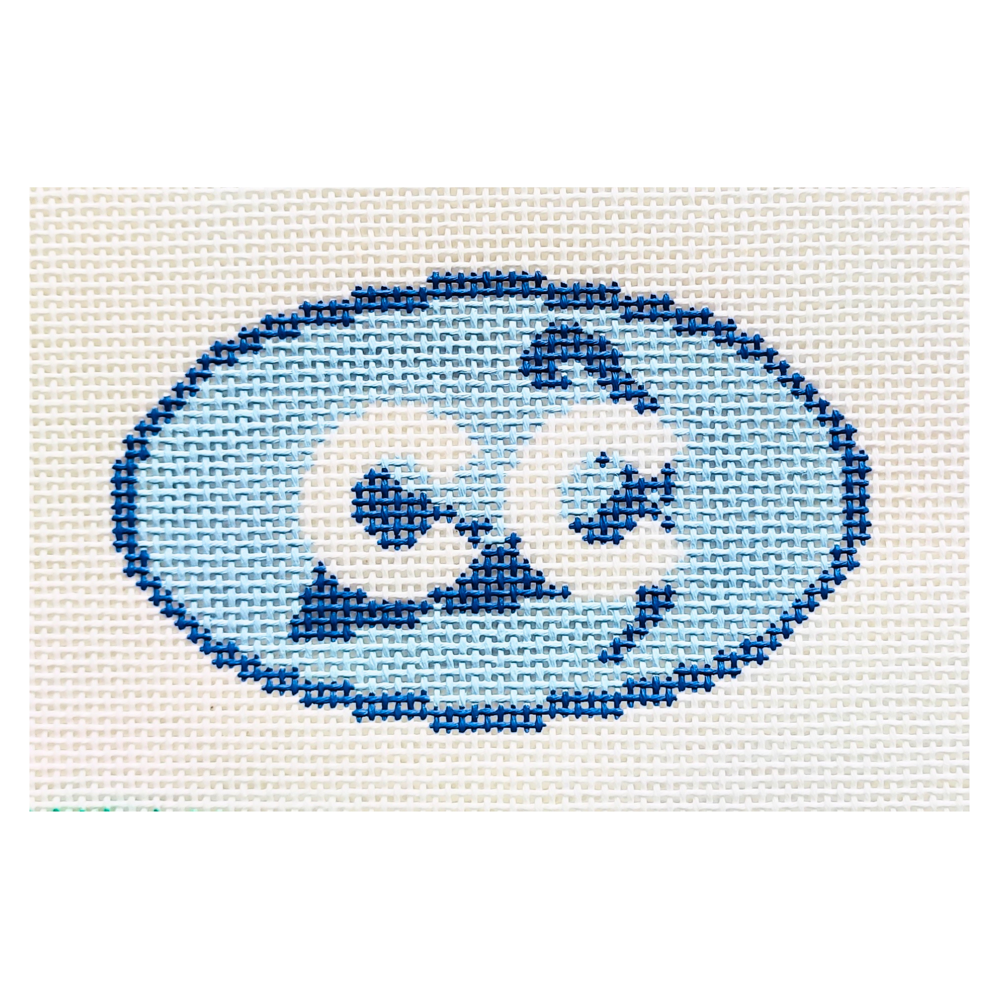 Needpoint design of a blue oval with the letters CC in white.