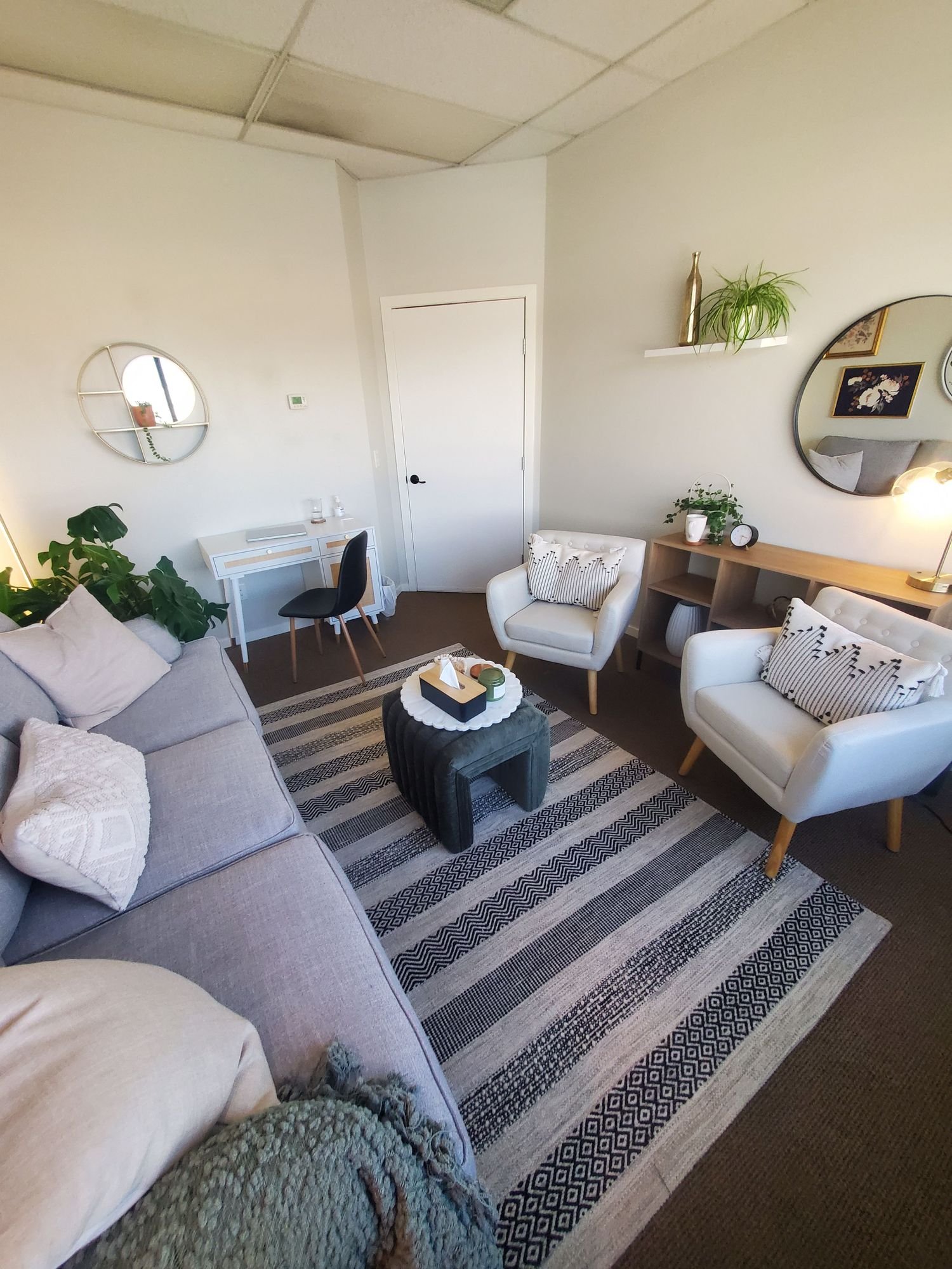 cozy therapy office in Kelowna with natural lighting and comfortable chairs welcoming counselling space in Kelowna with natural light private therapy room designed for comfort and calm