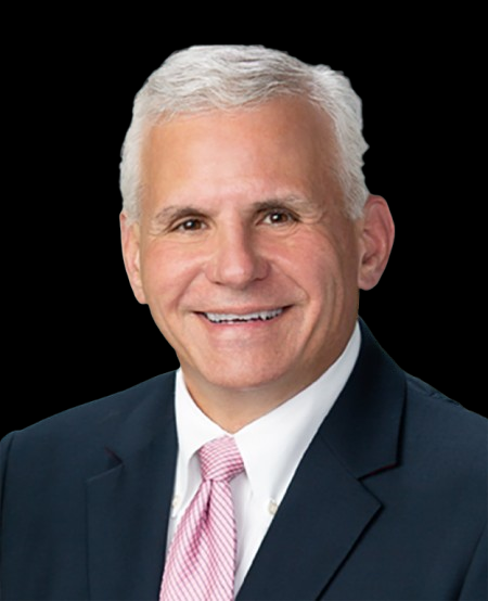 Smiling elderly man in suit and pink tie on black background.