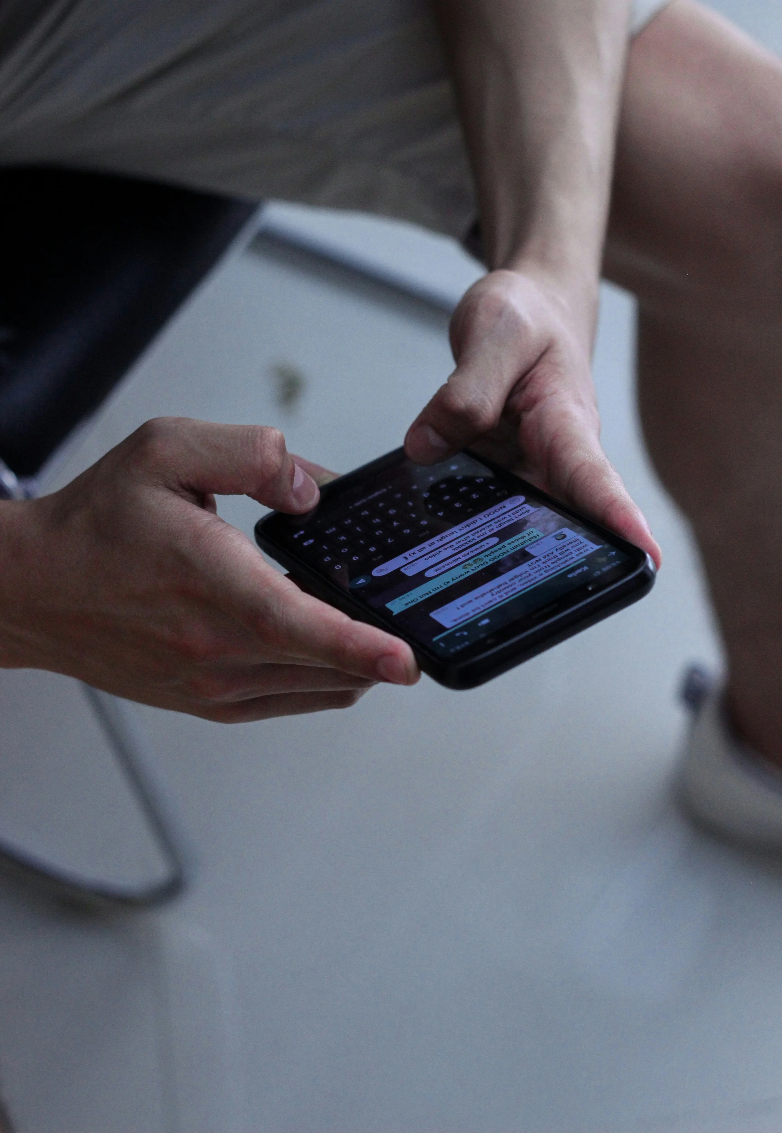 Person holding a smartphone displaying a messaging app with multiple text messages.