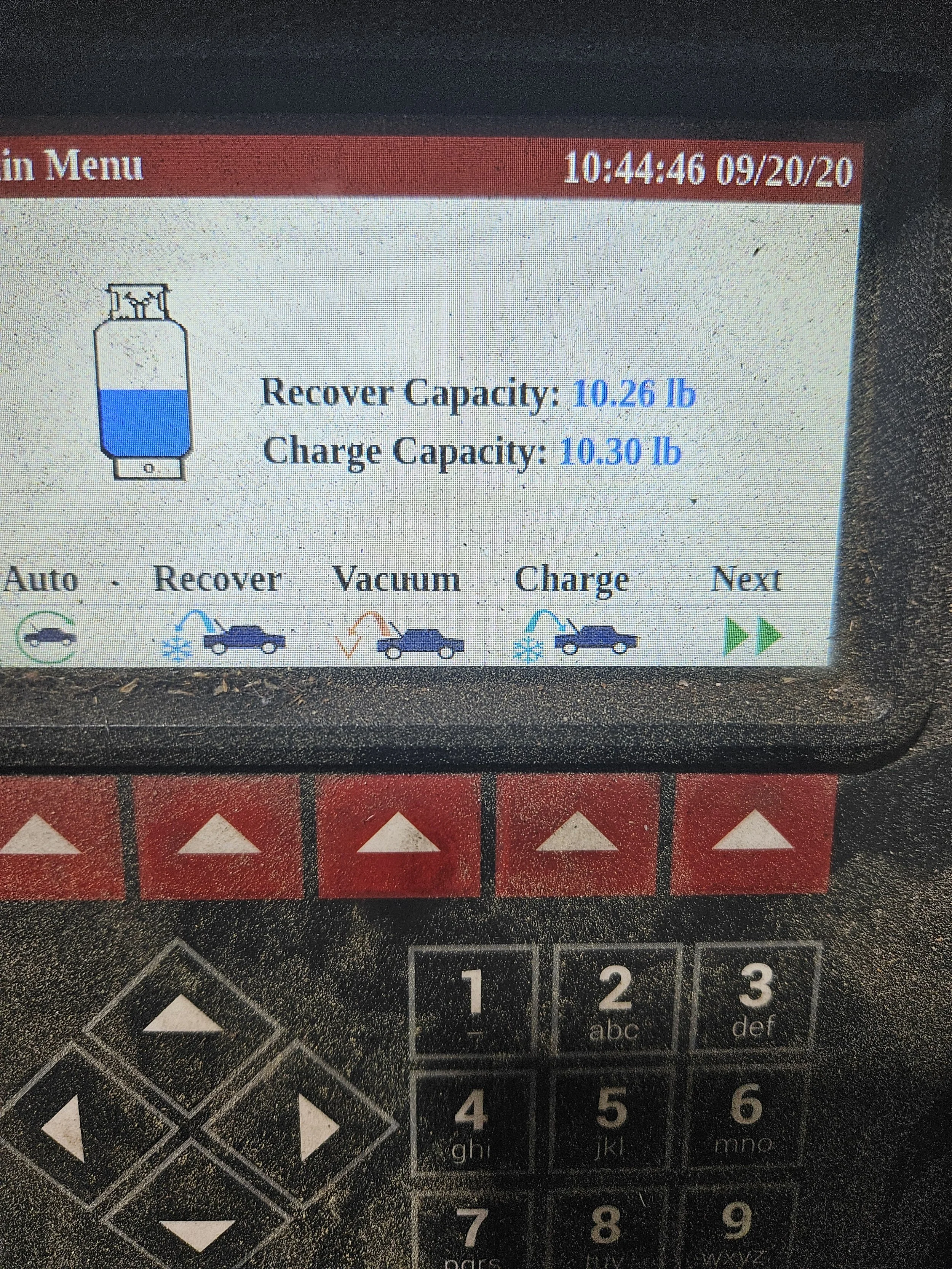 A screen displaying a tire pressure monitoring system with information about the tire's recover and charge capacities, along with buttons for auto, recover, vacuum, and charge functions, and a keypad below.