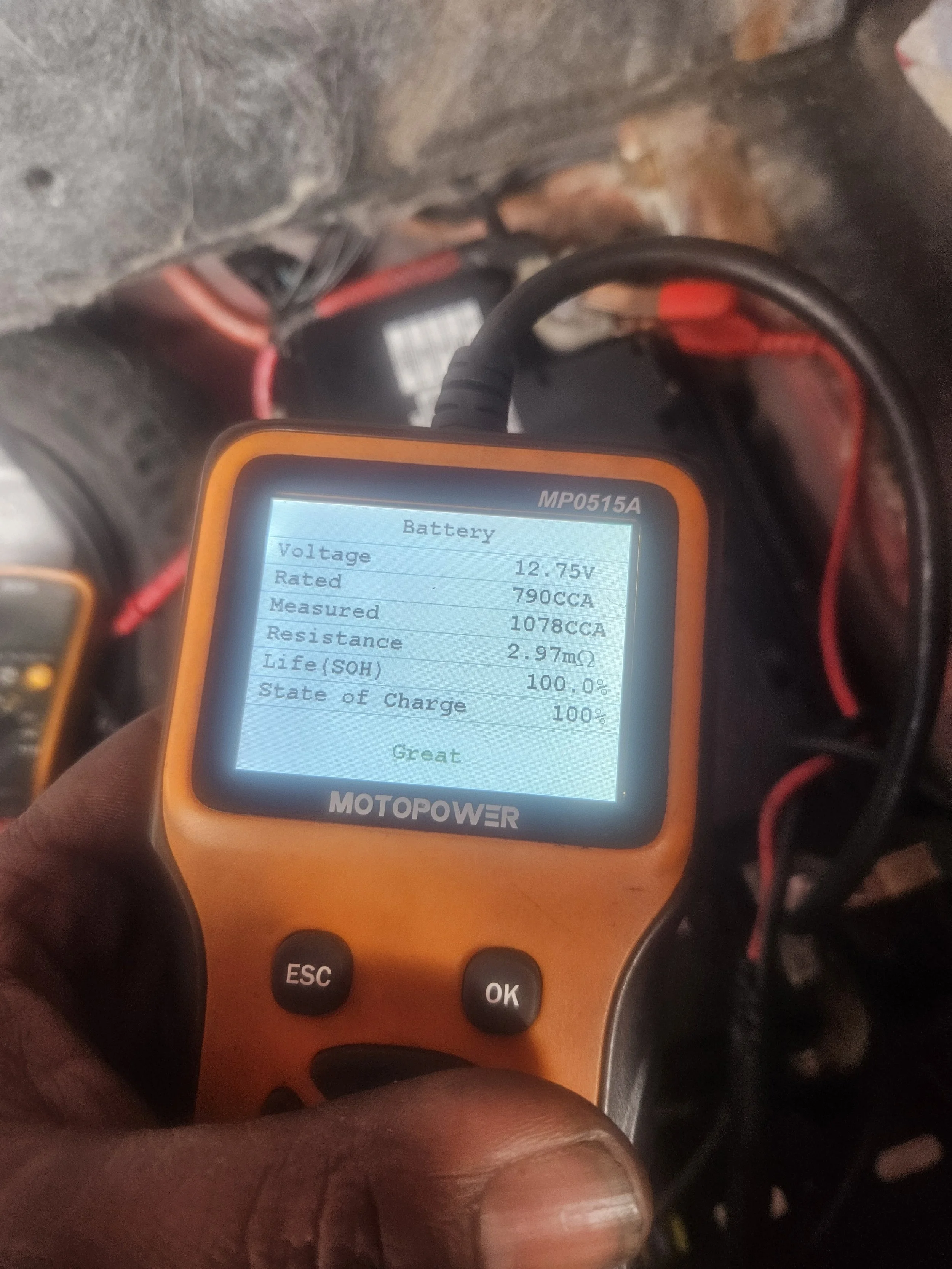 A digital battery tester displaying voltage of 12.75V, rated at 790CCA, measured at 1078CCA, resistance of 2.97 milliohms, and a state of charge of 100%.