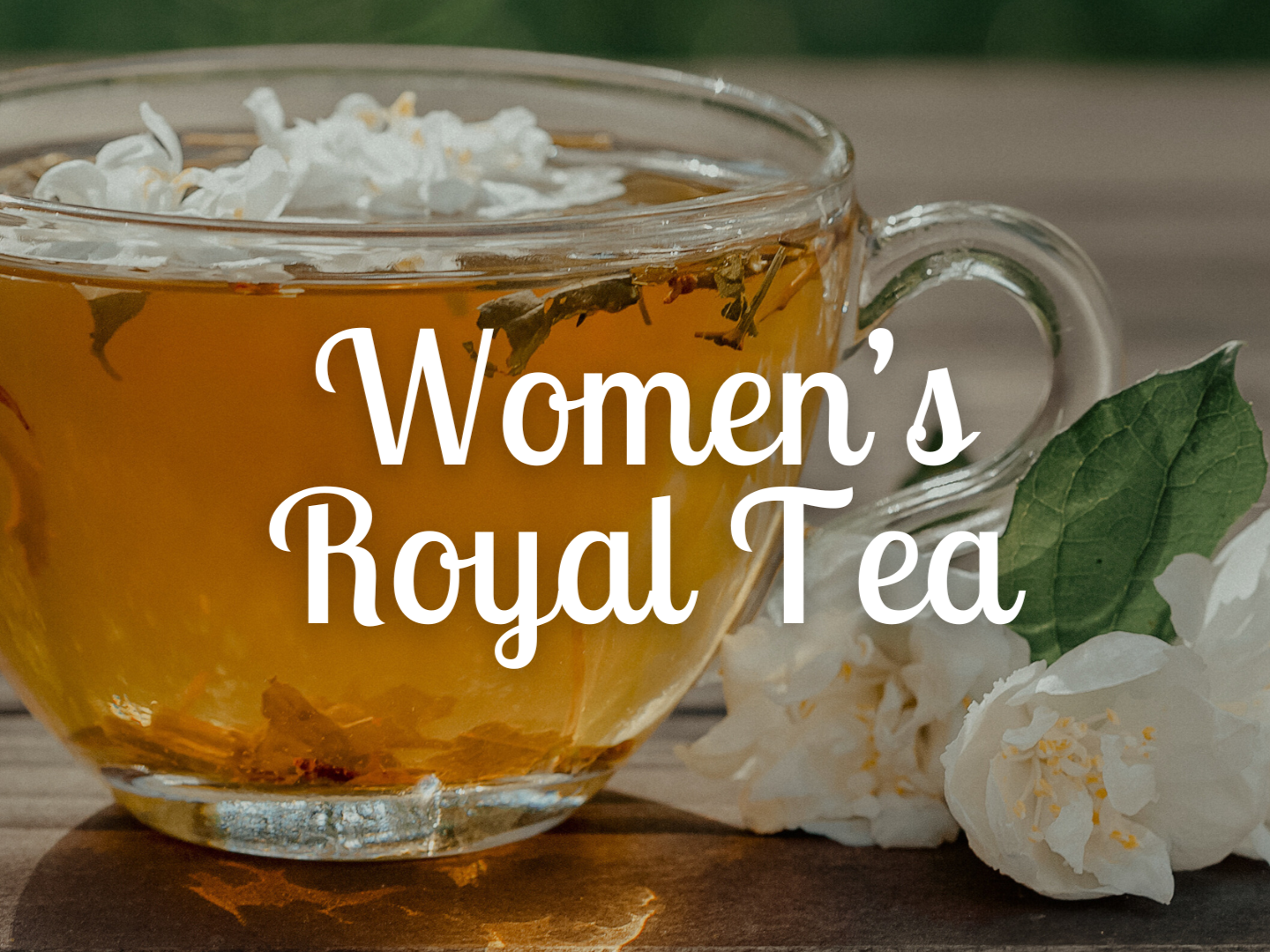 A cup of women’s royal tea with whipped cream on top, placed on a wooden surface with white flowers and green leaves beside it.