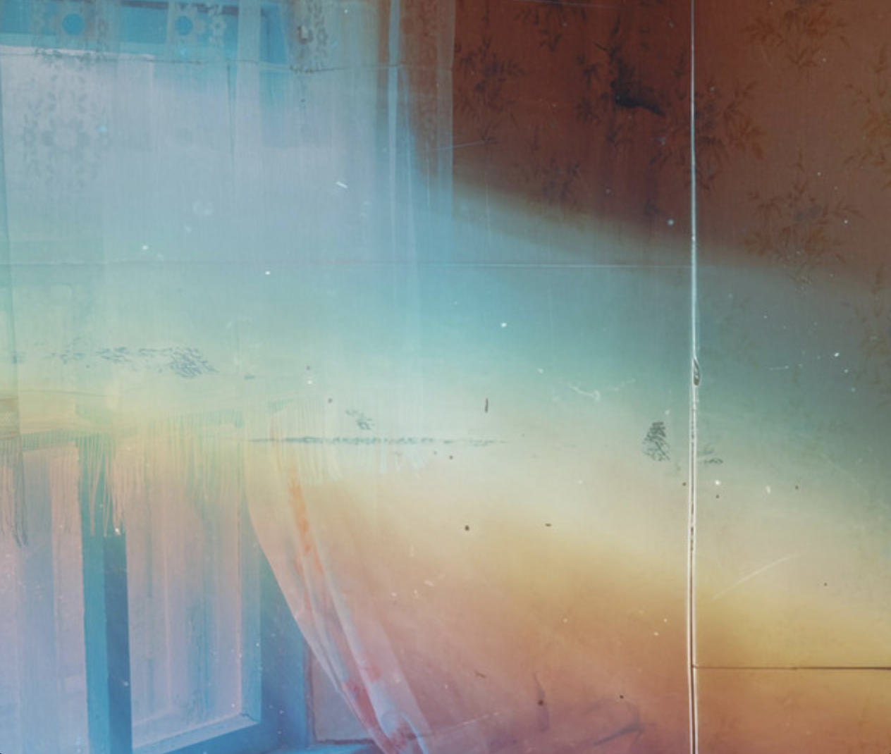 Abstract colorful wall with a mix of light blue, orange, and yellow hues, and a vertical line in the center.