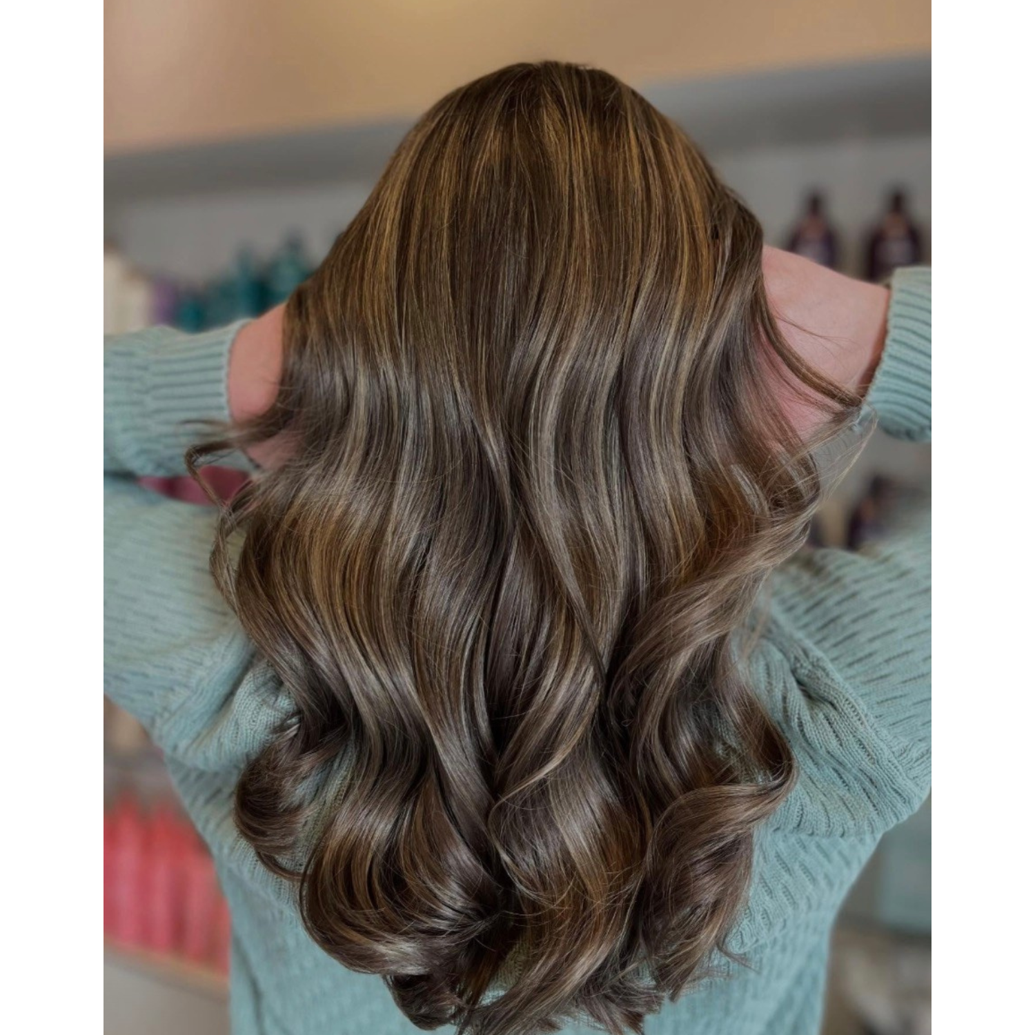 Back view of a woman with long, wavy, light brown hair.