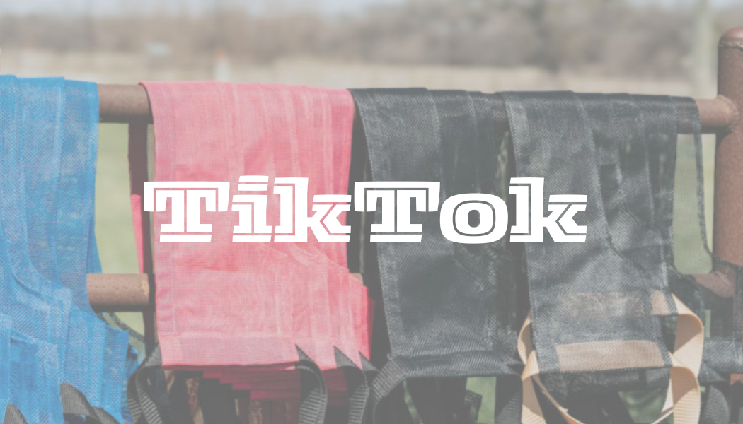 Colorful hammocks hanging on a metal fence outdoors with the text 'Tik Tok' in the center.