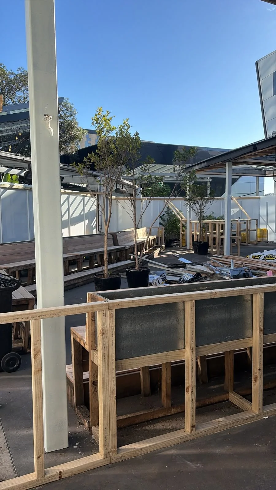 Outdoor area of Sports & Rec Bar taking shape, with timber decking and planter boxes under construction.