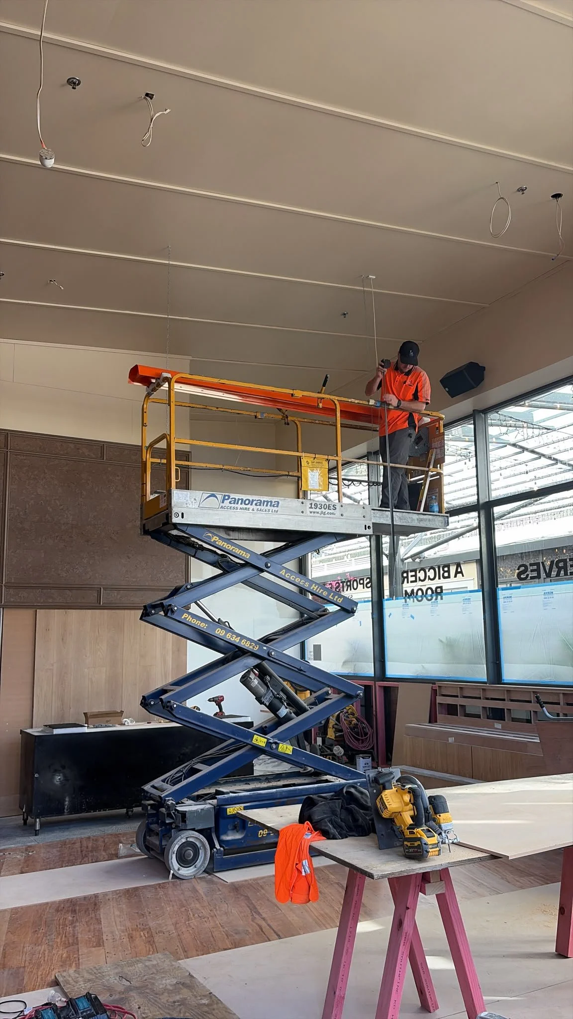 Form & Finish crew installing interior wall panelling and joinery at Sports & Rec Bar using scissor lift access.