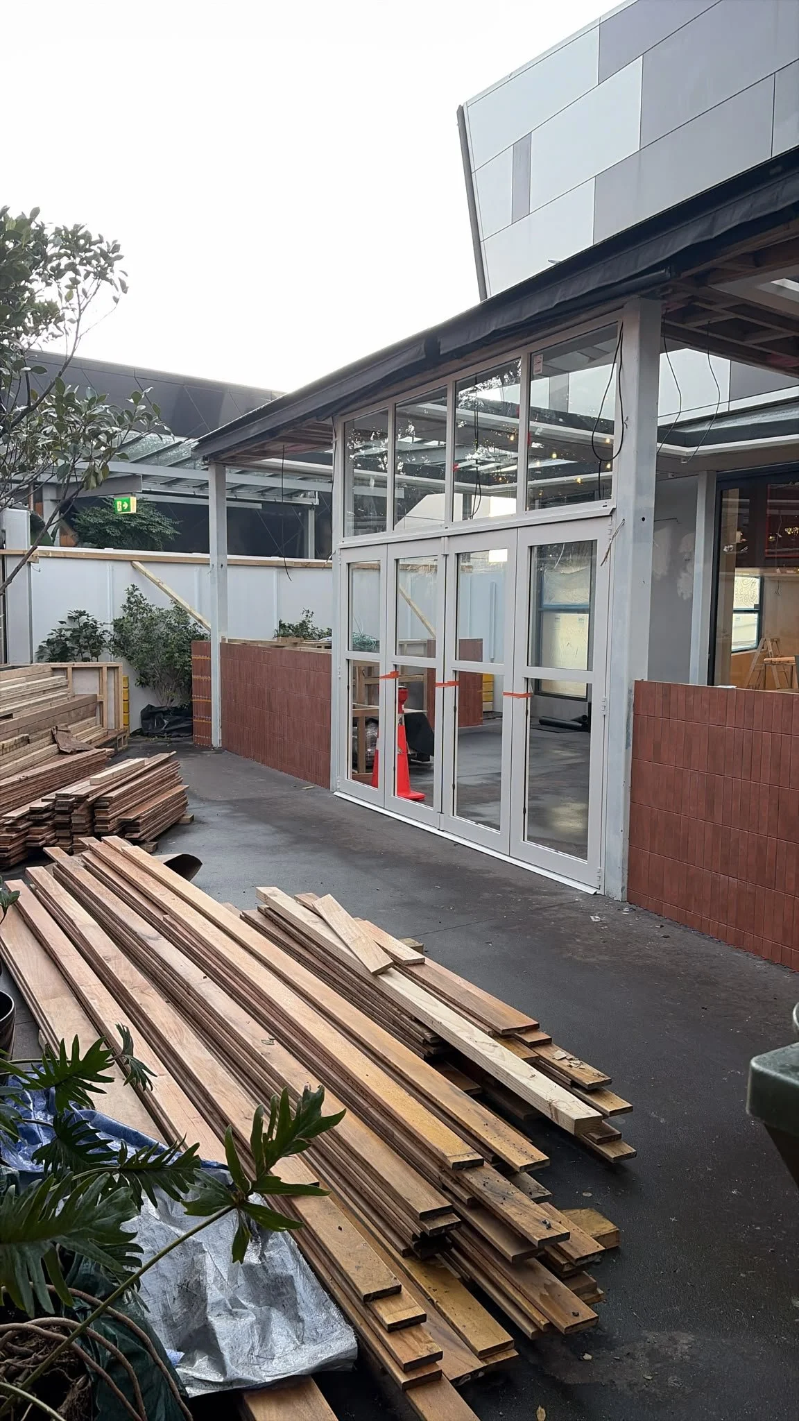 Exterior of Sports & Rec Bar during construction, with timber materials staged on site ready for installation.
