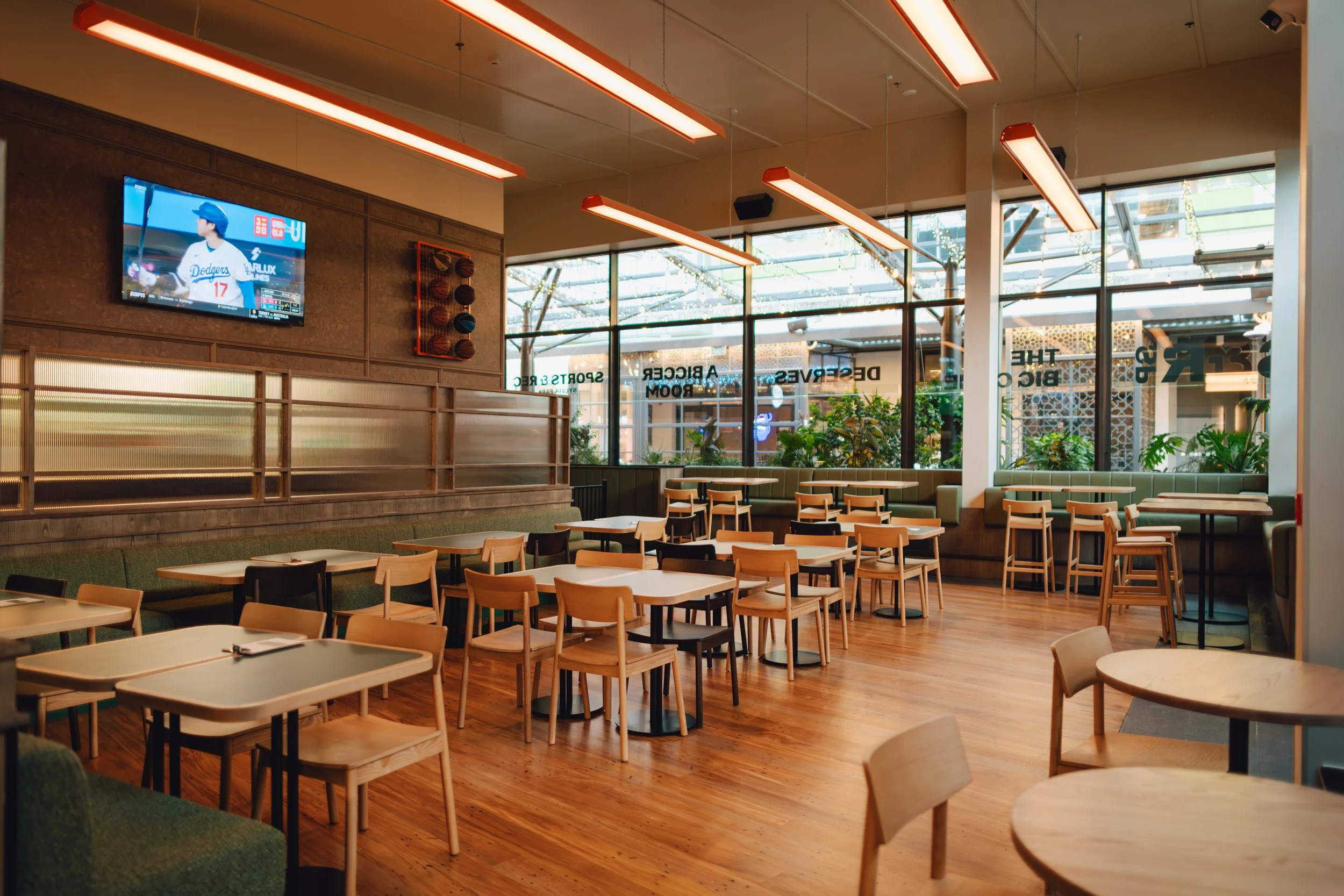 Completed dining area of Sports & Rec Bar, featuring timber flooring, custom booth seating and timber wall panelling.