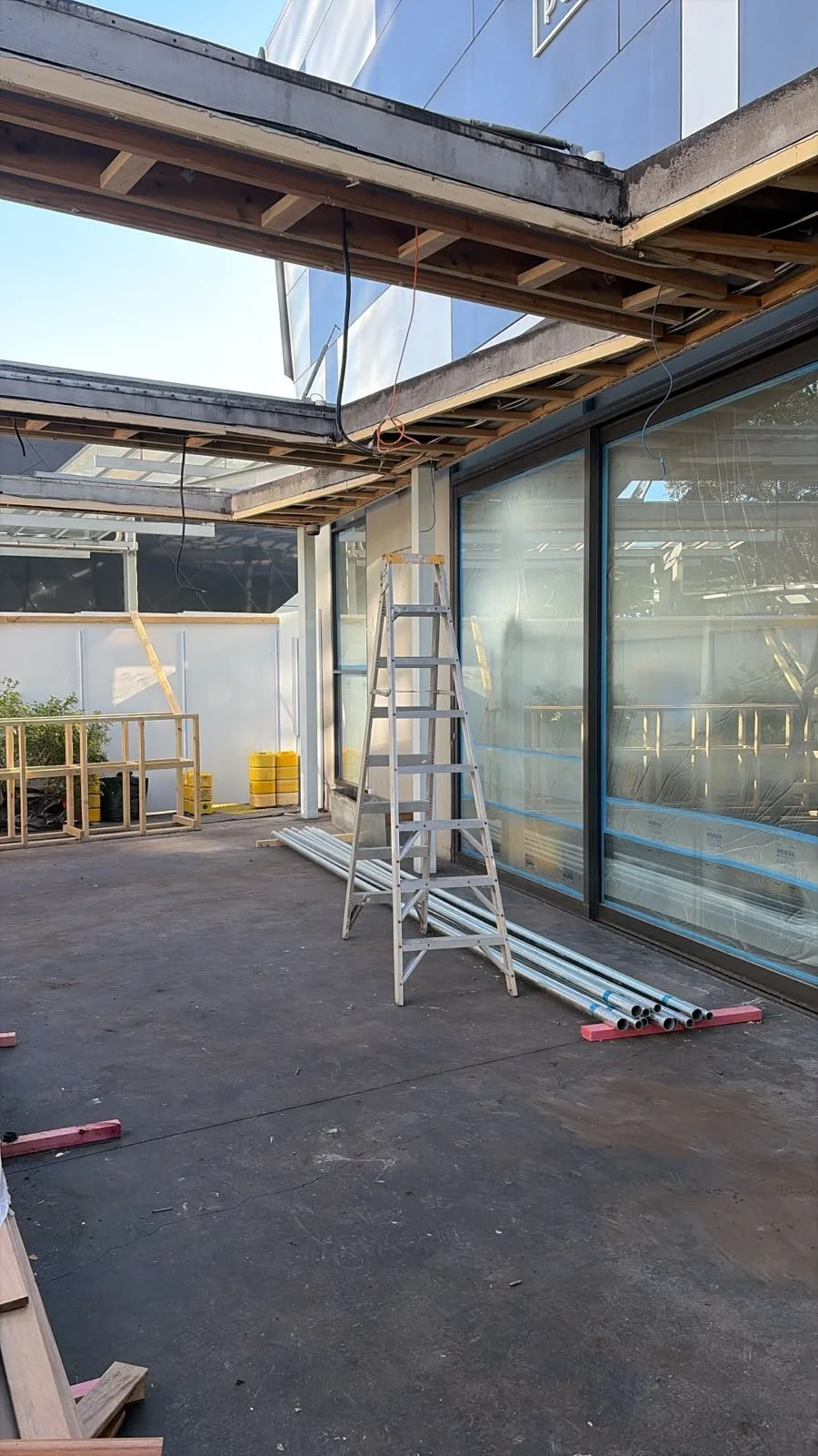 Outdoor area of Sports & Rec Bar during construction, with glazed facade and timber framing in progress.