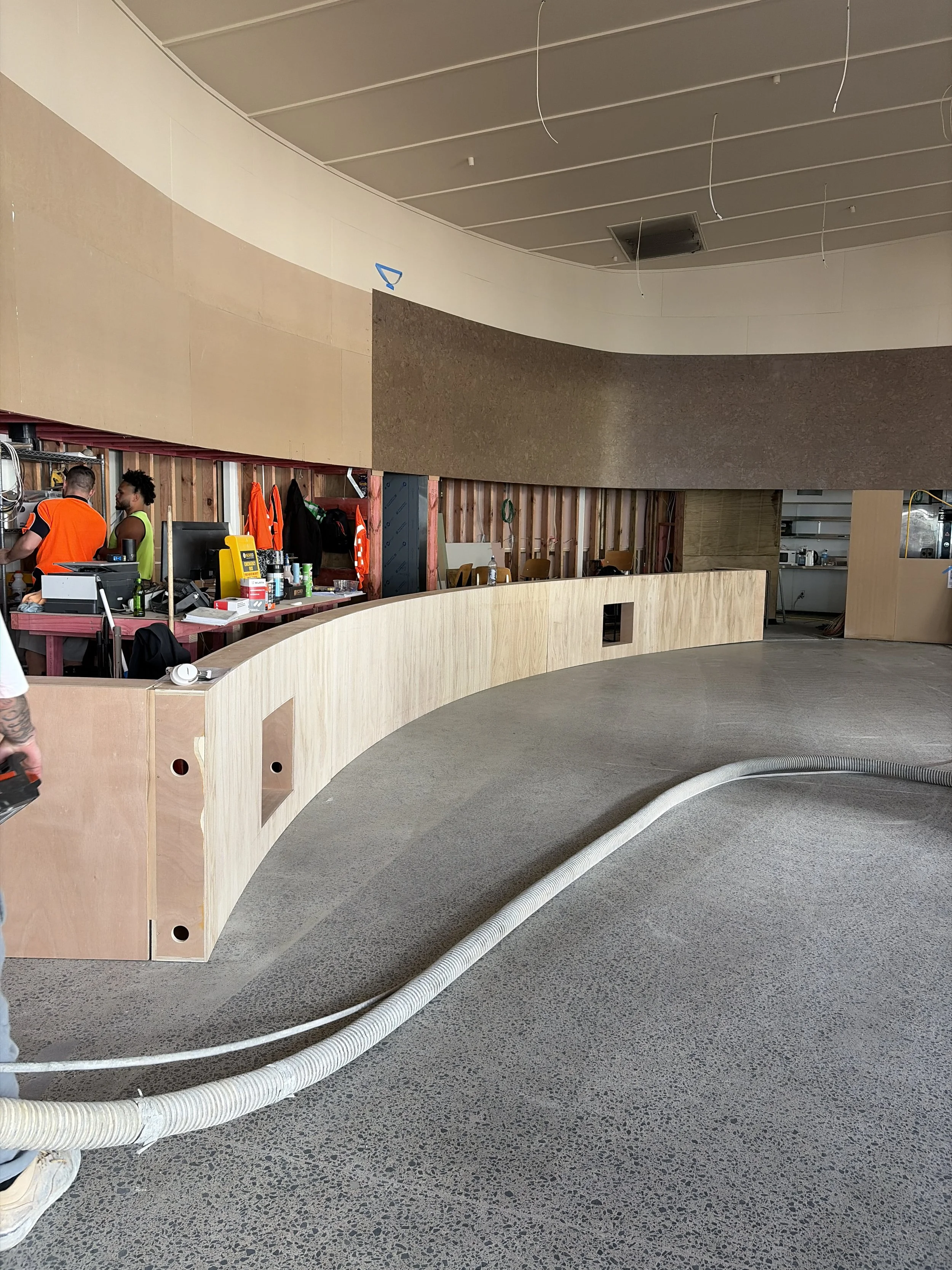 Curved bar counter joinery installed by Form & Finish at Sports & Rec Bar, with cork wall lining and timber panelling in progress.