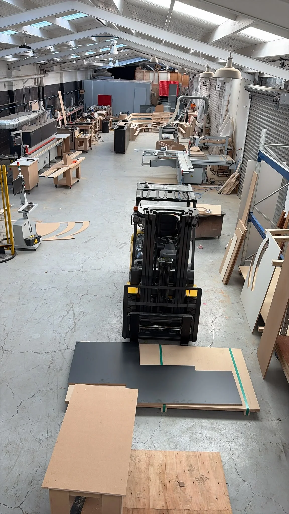 Overhead view of the Form & Finish workshop, Onehunga, showing the full production floor with industrial machinery, timber materials and a forklift in operation
