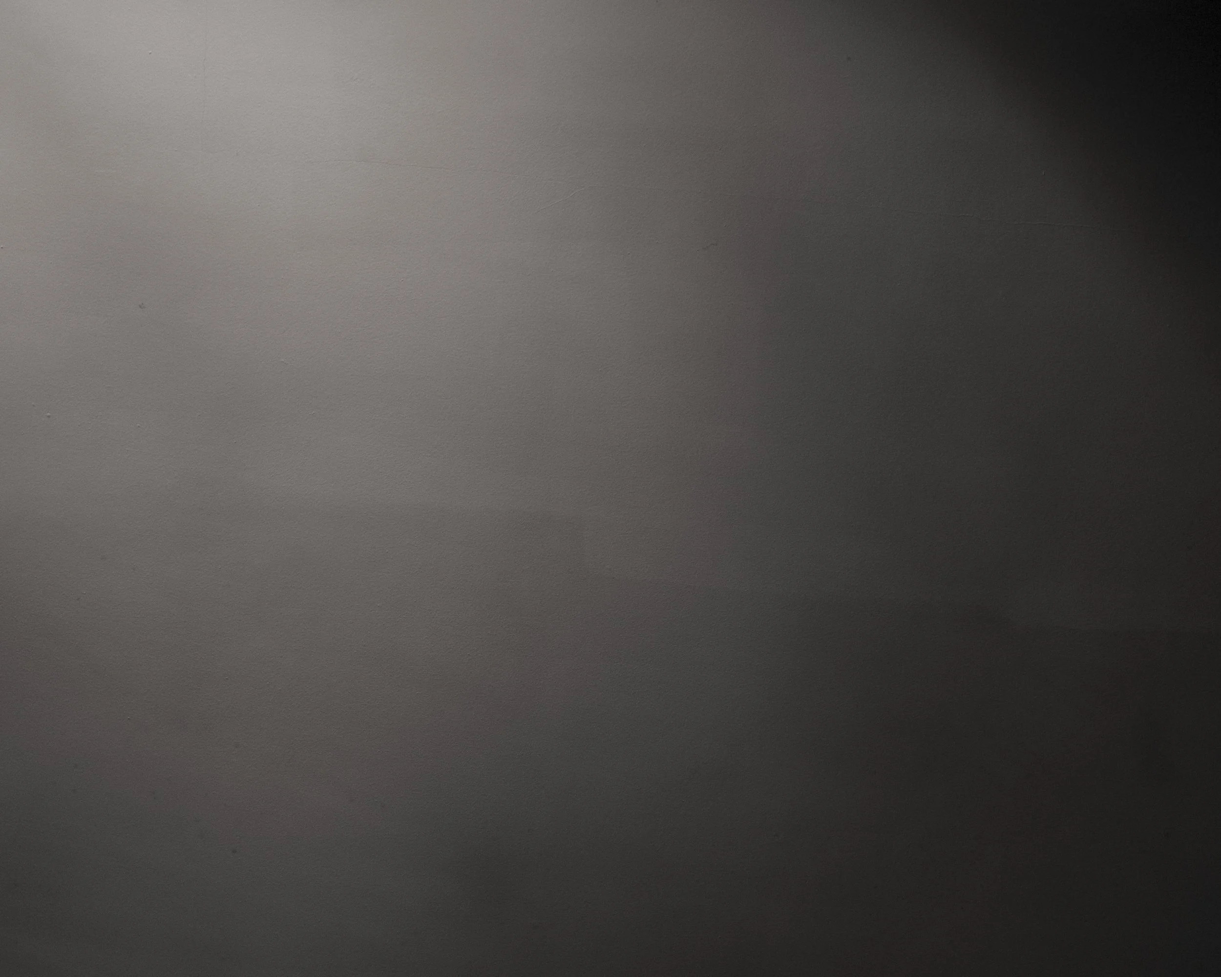 A plain, gray surface with slight texture and shadows.