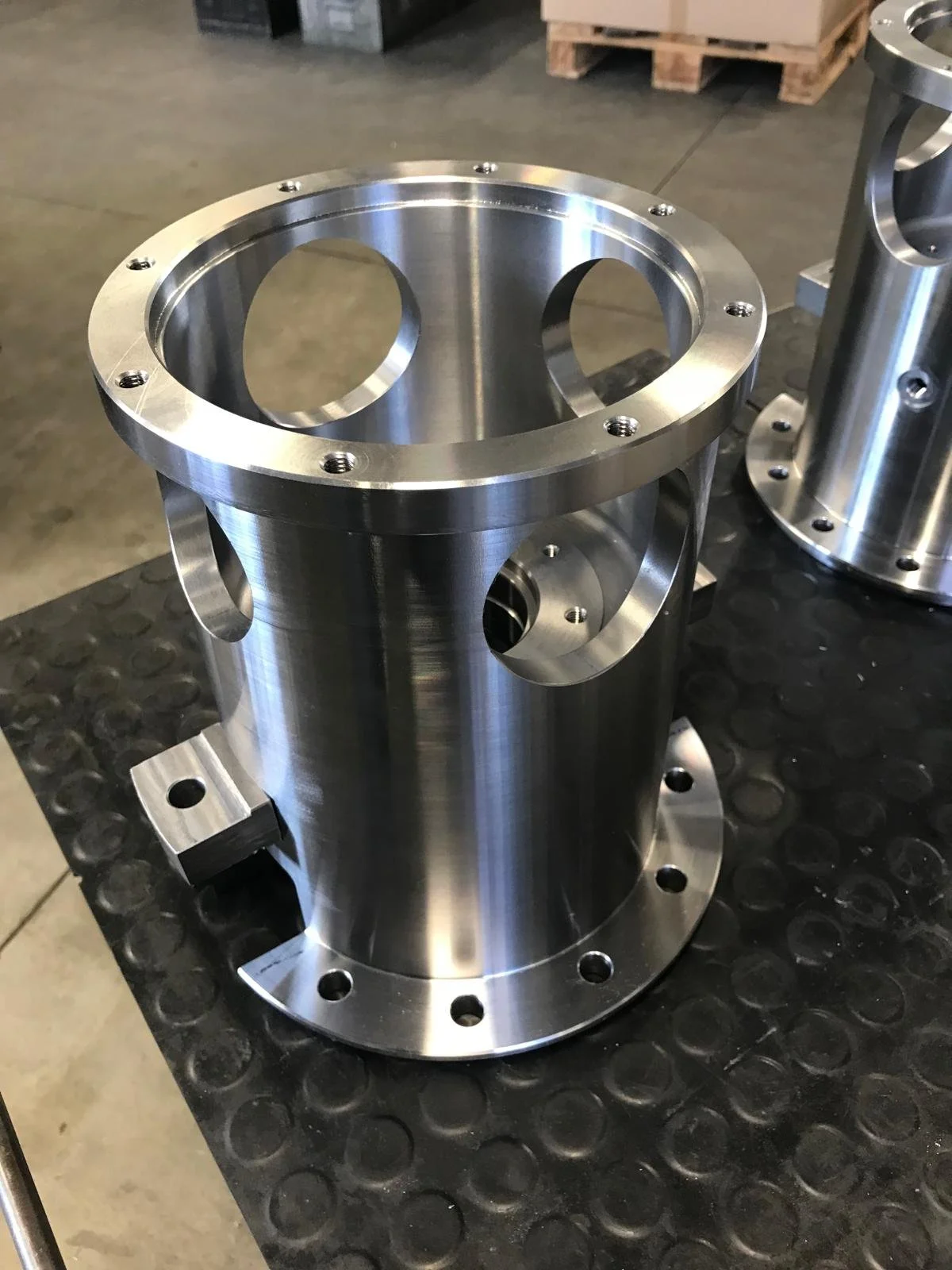 Particolare di un pezzo di metallo cilindrico con fori e scanalature di precisione.