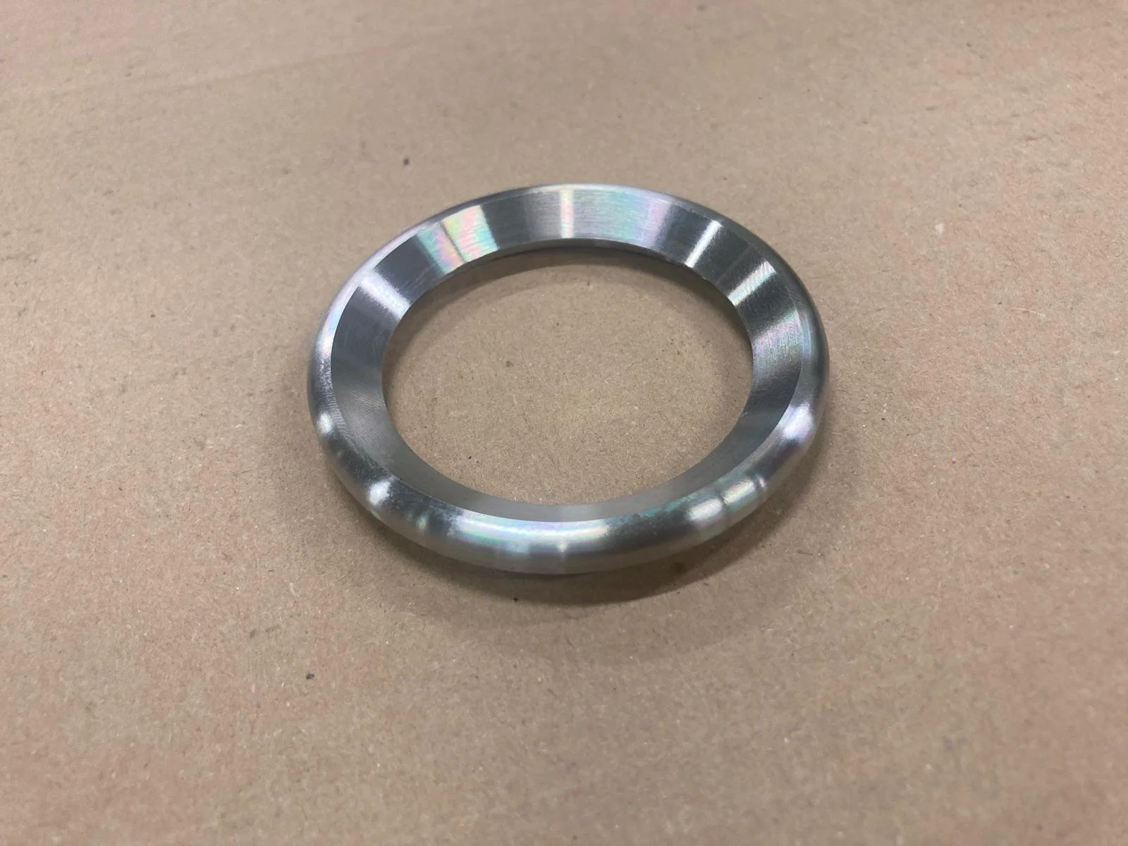 Anello in metallo su sfondo beige.