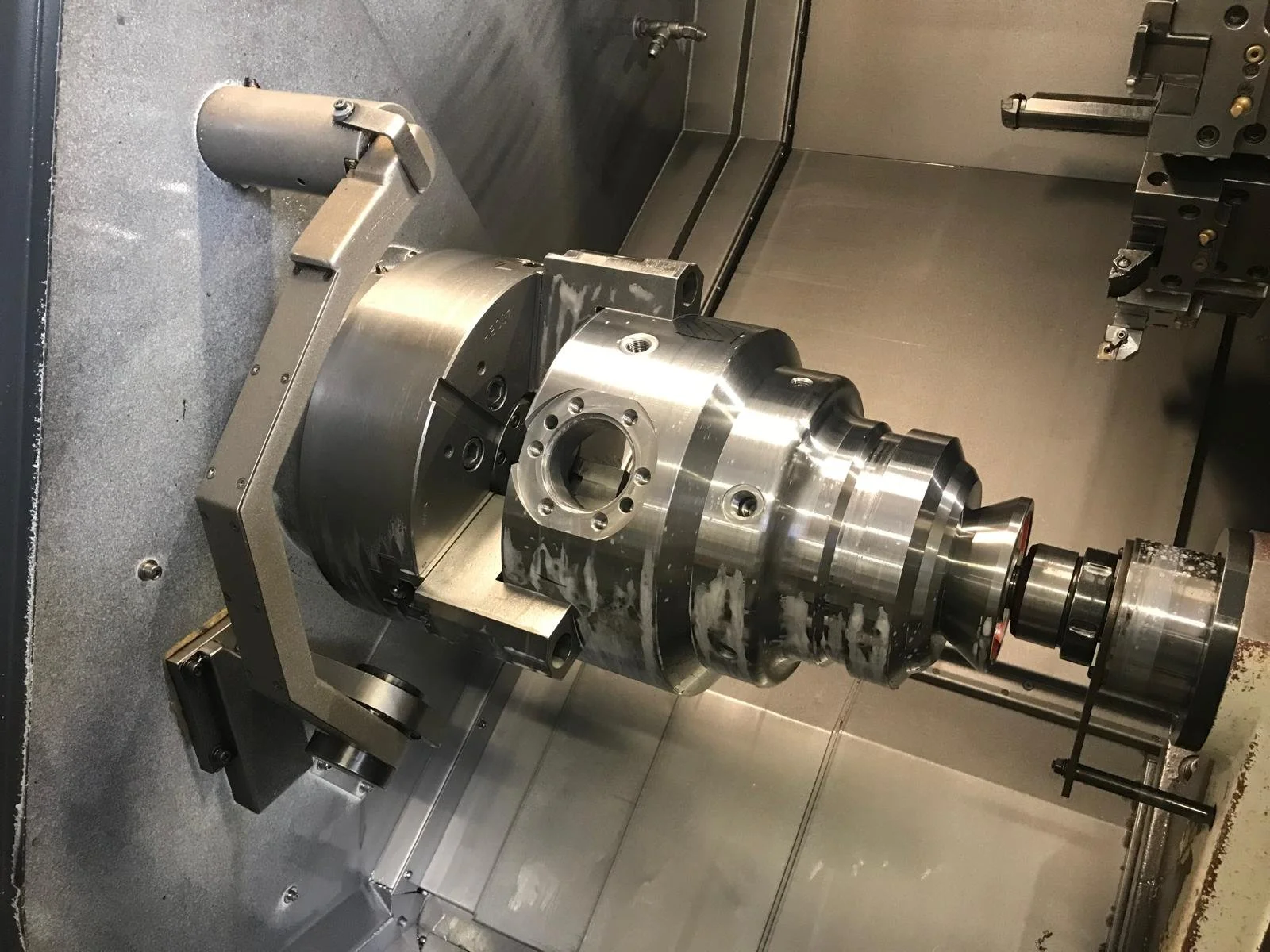 Particolare macchina CNC con importante componente meccanico in acciaio.