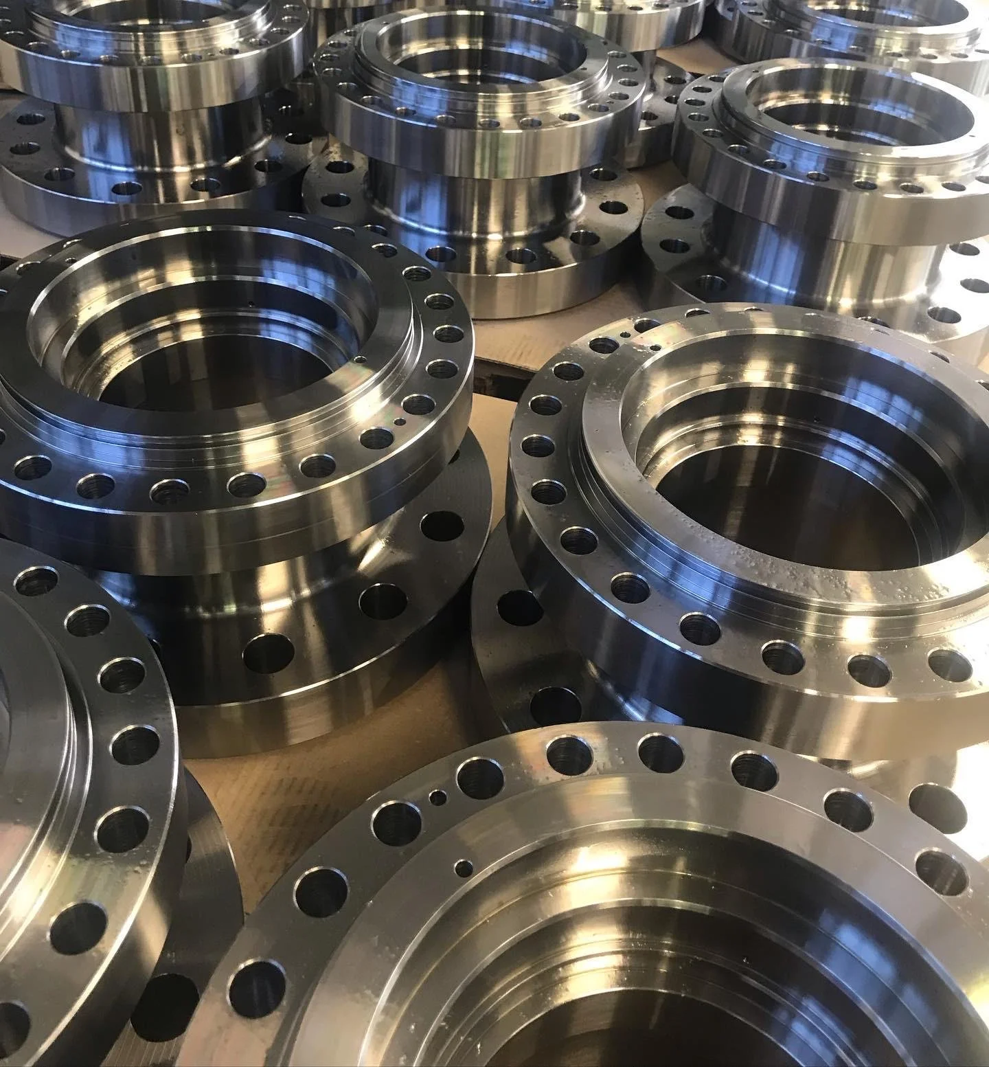 Anelli metallici con fori disposti in cerchio, disposti su una superficie di legno.