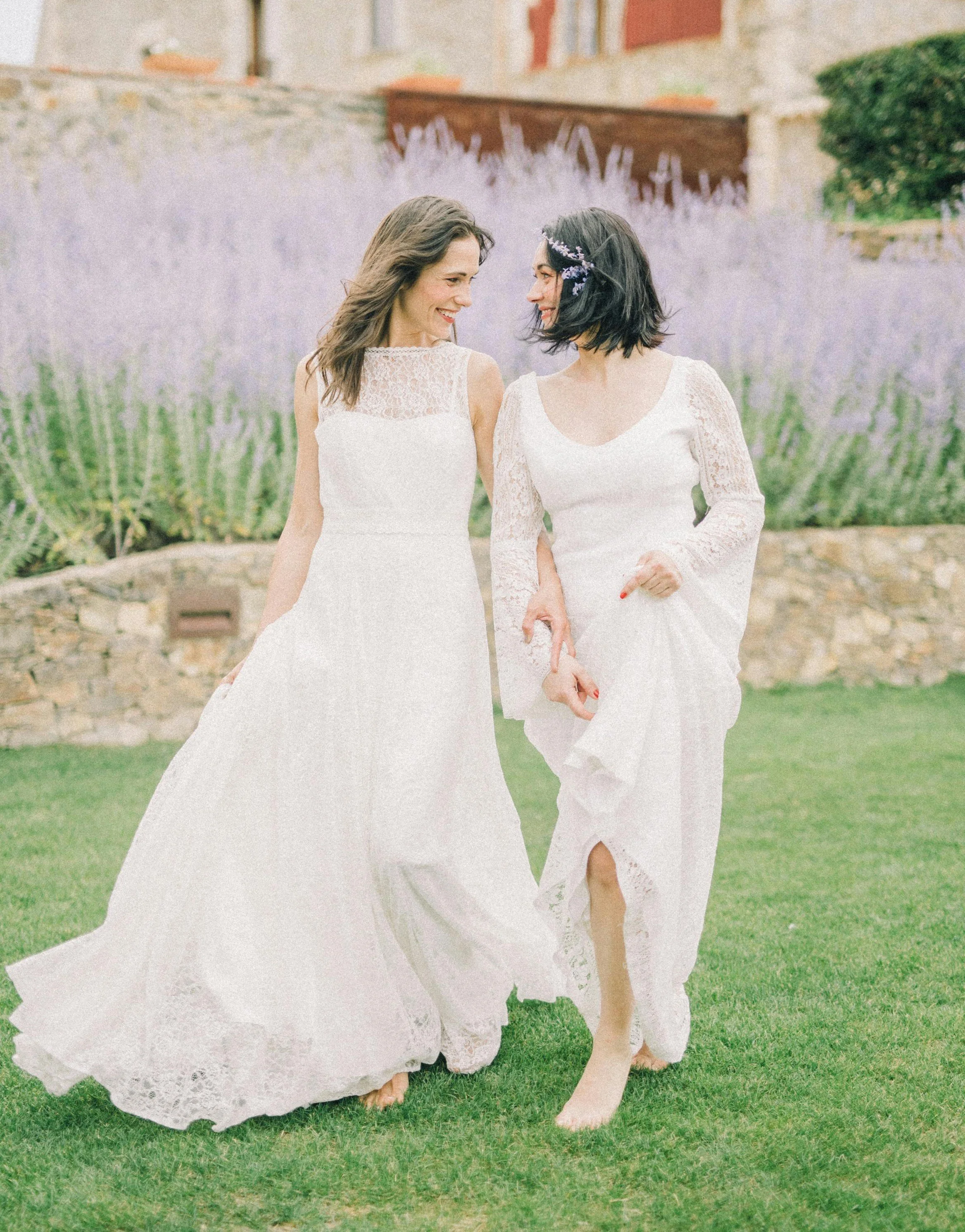 Laurie’s customers, Mariana and Carmen holding hands on a green lawn on their wedding day.
