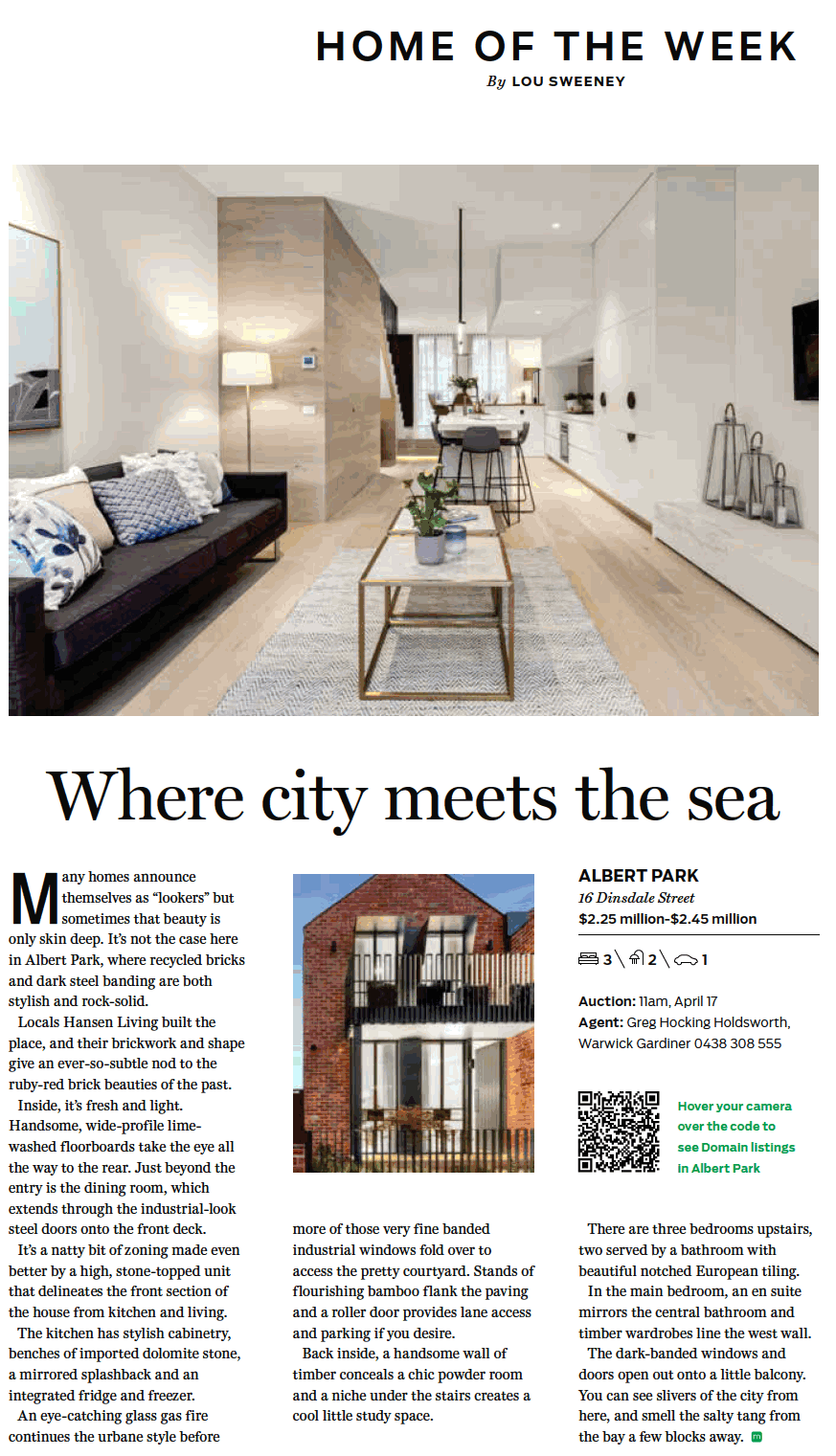 Interior view of a modern, minimalistic living room with a black sofa, light wood flooring, a white coffee table with plants, and a dining area in the background.