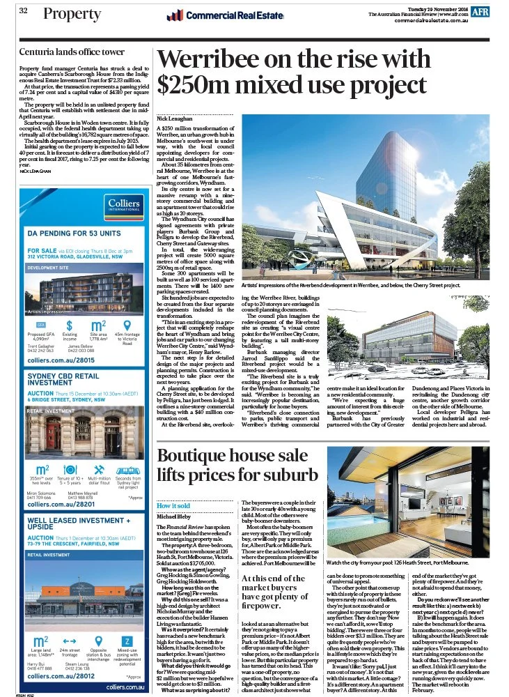 Photograph of a modern, multi-story commercial building with a sleek glass facade and some surrounding trees, located in Warrnambool, Australia.