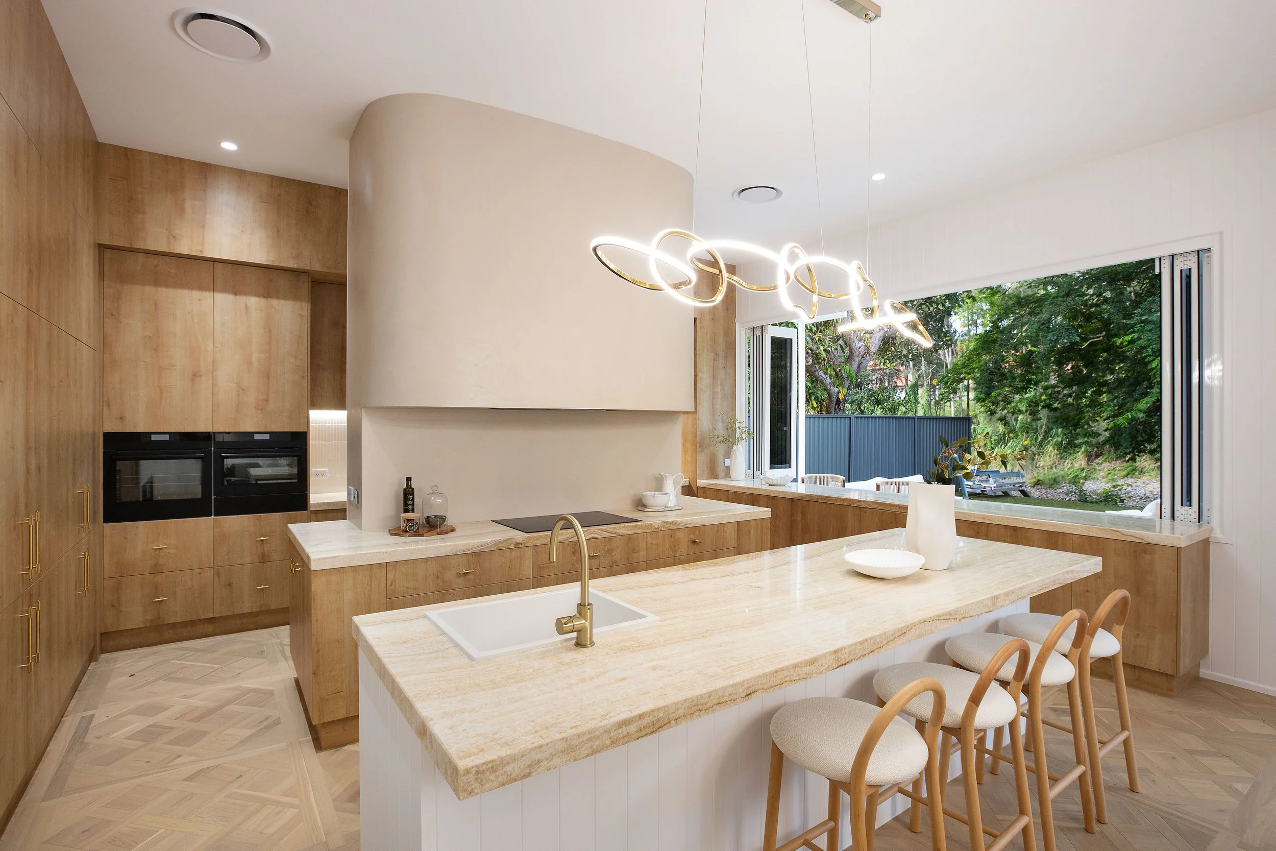 Luxury kitchen renovation on the Gold Coast featuring timber cabinetry, stone benchtops and a large kitchen island.