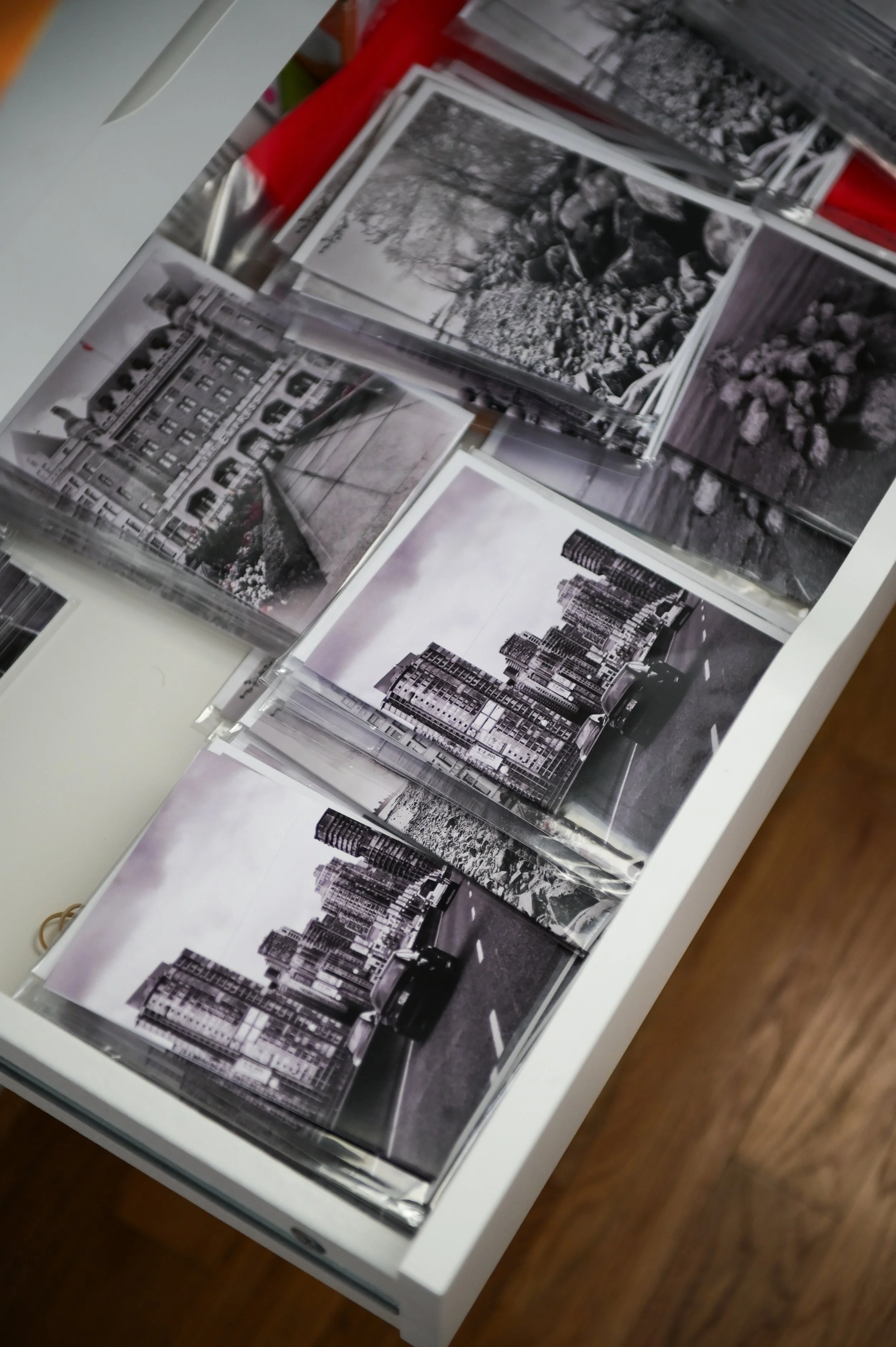 A collection of black and white photographs of cityscapes and urban scenes on a white surface.