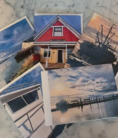Collection of five seaside photographs including a boat dock, a house, a fishing boat at sunset, and a pier over the water.