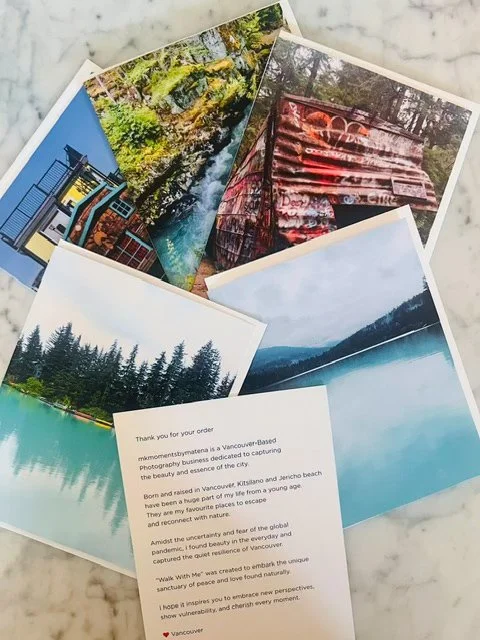 A collection of printed photographs depicting outdoor scenes including forests, rivers, cabins, and scenic landscapes arranged on a marble surface.