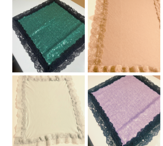 Four fabric or decorative box covers in green, pink, cream, and purple with lace edging.