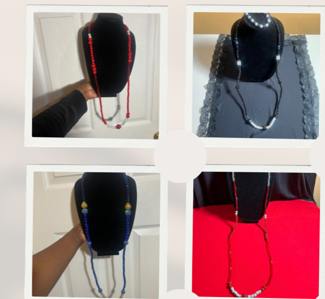 Four necklaces displayed on black jewelry busts, each with different colored beads: red, black, blue, and a combination of red and white beads.