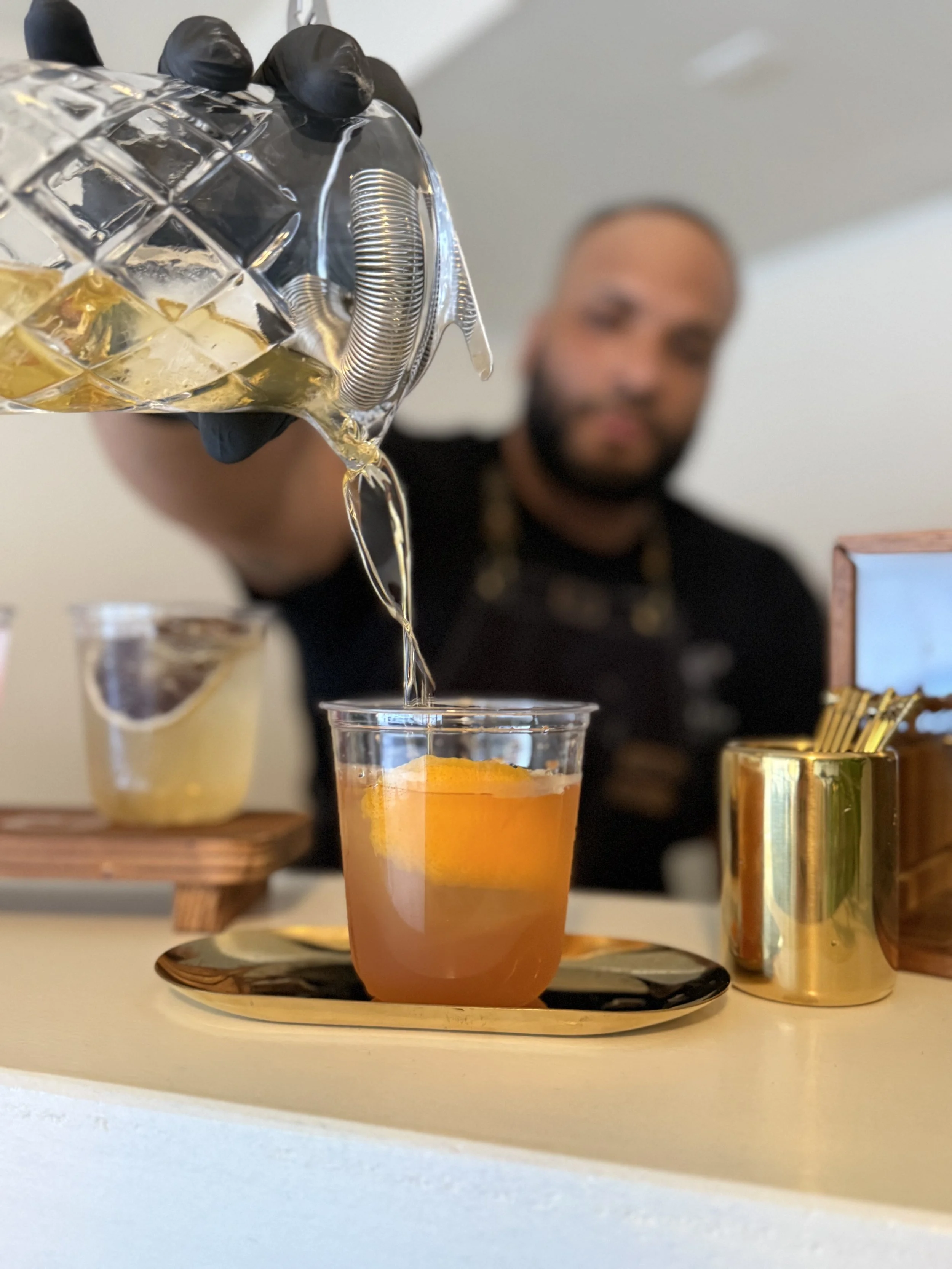Co-Founder and Bartending serving clients a freshly made old fashioned cocktail