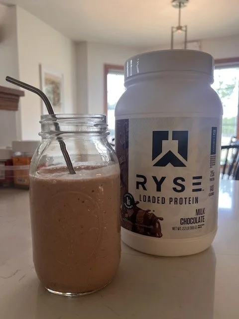 Ryse Loaded Protein chocolate smoothie in a mason jar next to the protein powder container