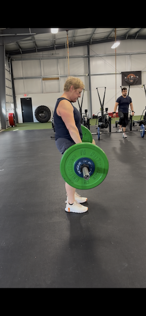 Sandra deadlifting at CrossFit at 60 years old with spondylolisthesis, proving movement is medicine