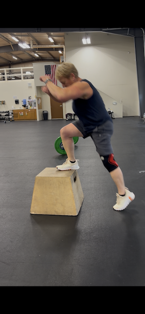 Sandra doing box jumps at CrossFit wearing her Nike training shoes
