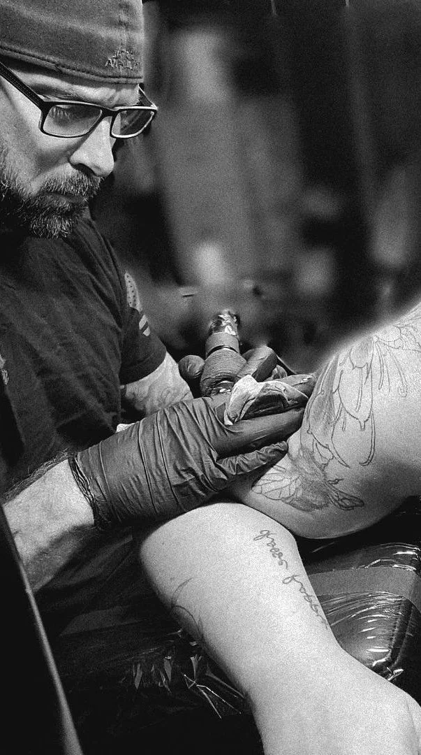 Owner, Darryl Emrath, tattooing a client at his shop in Saint Joseph, MI.