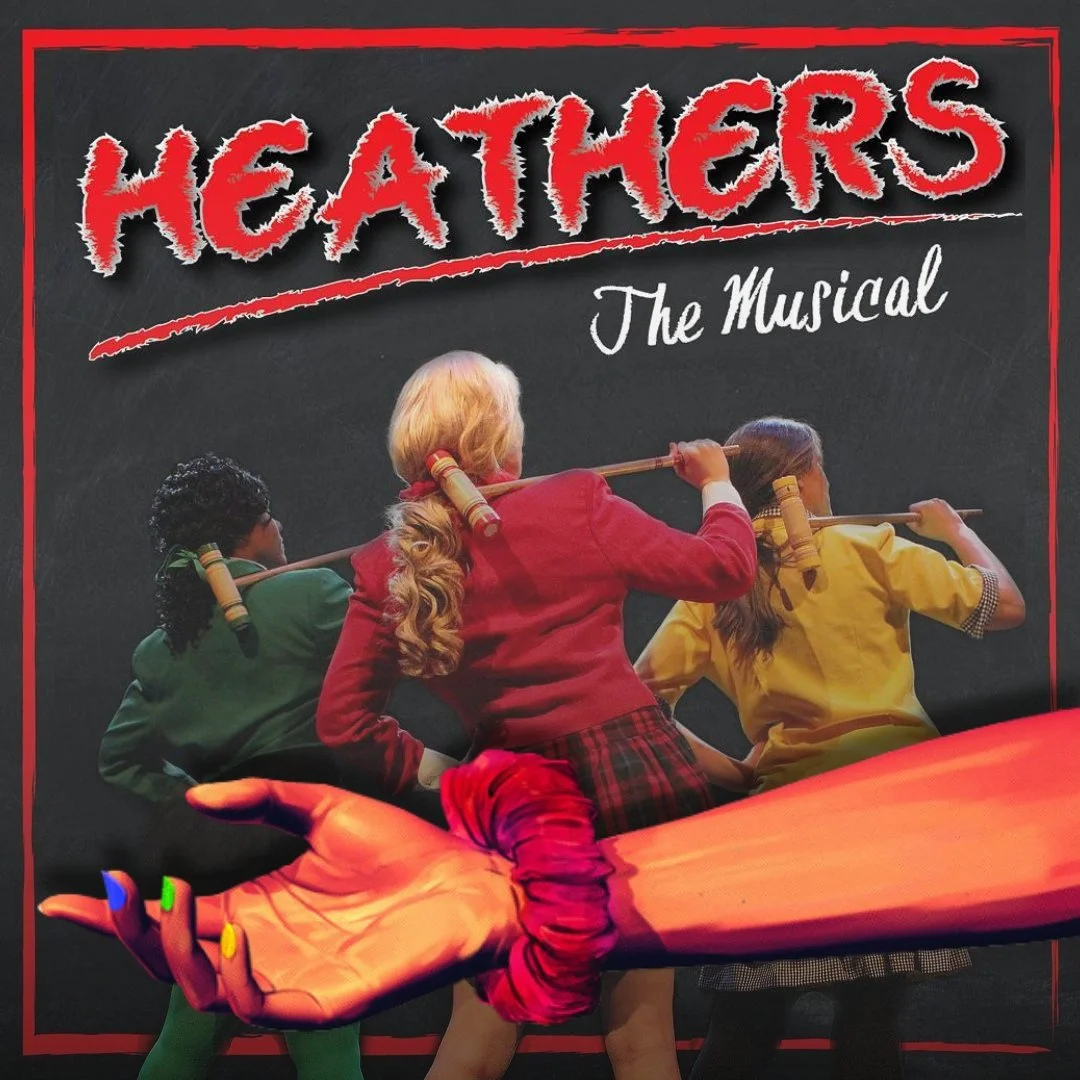Promotional poster for 'Heathers: The Musical' featuring three young women dressed as schoolgirls in green, red, and yellow uniforms, holding large wooden mallets over their shoulders, with the title 'Heathers' in bold red letters at the top.