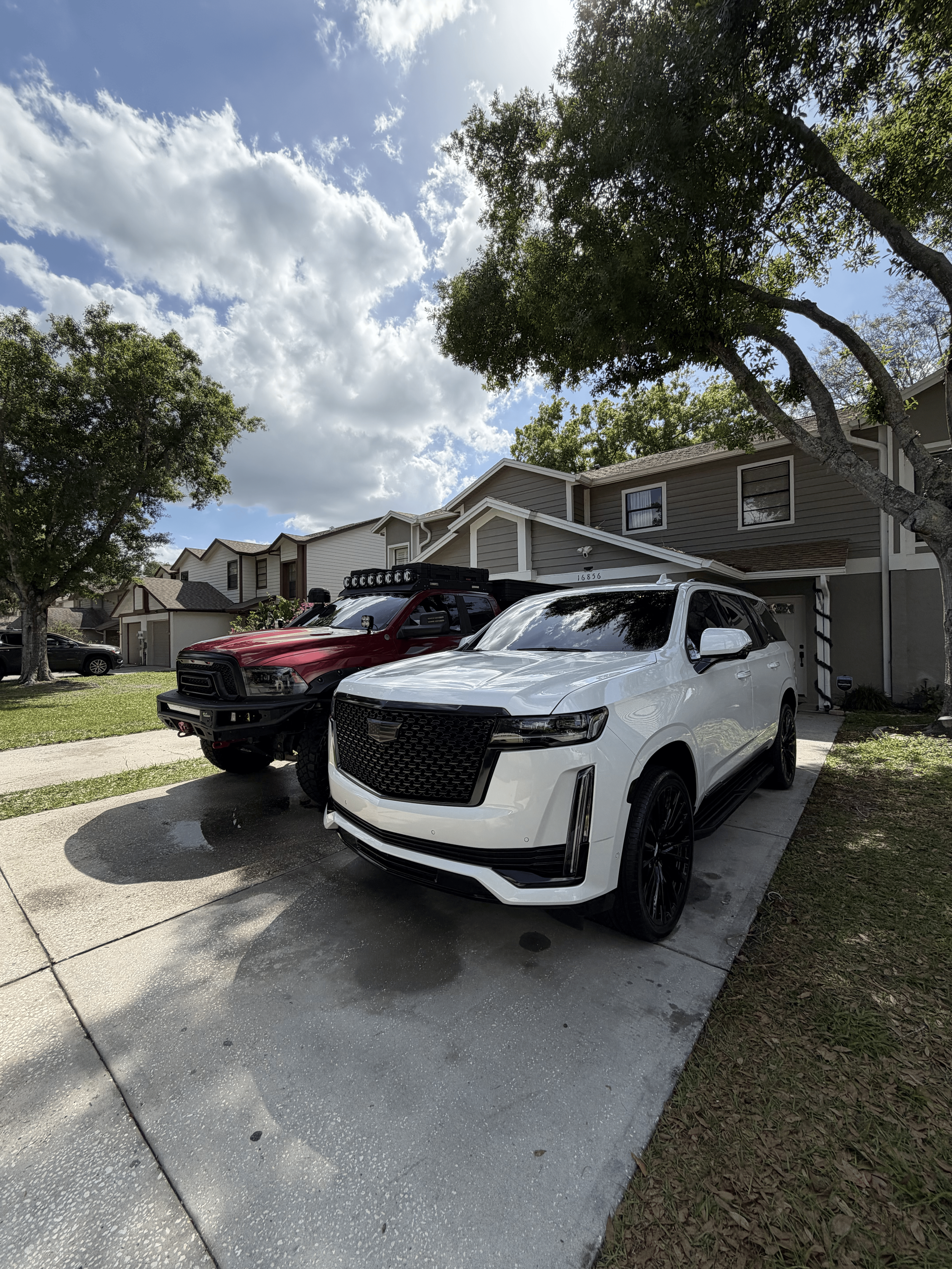 Mobile detailing service on Cadillac Escalade and lifted RAM truck in Tampa FL driveway