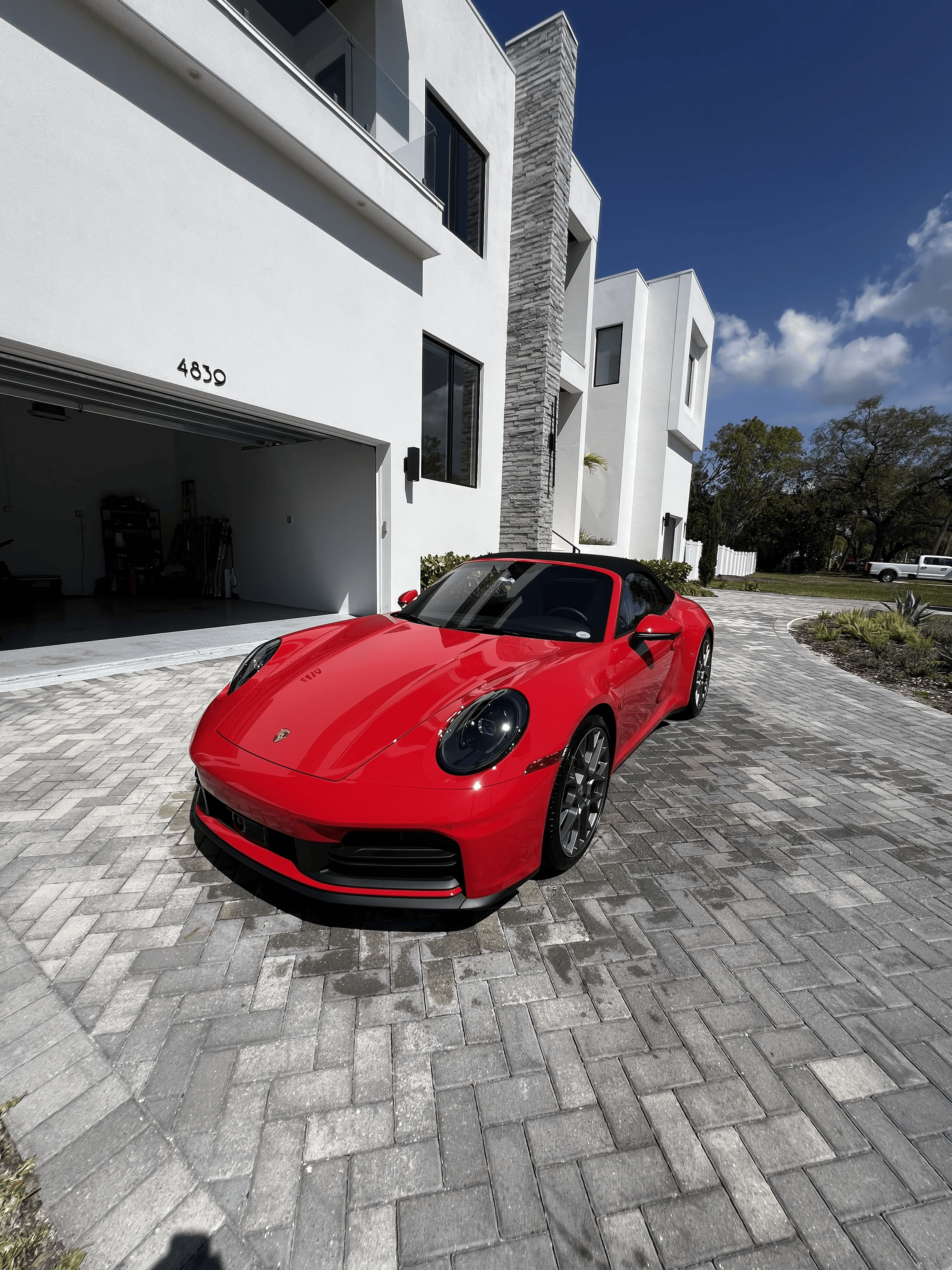 Professional exterior detailing on red Porsche 911 at luxury Tampa FL home