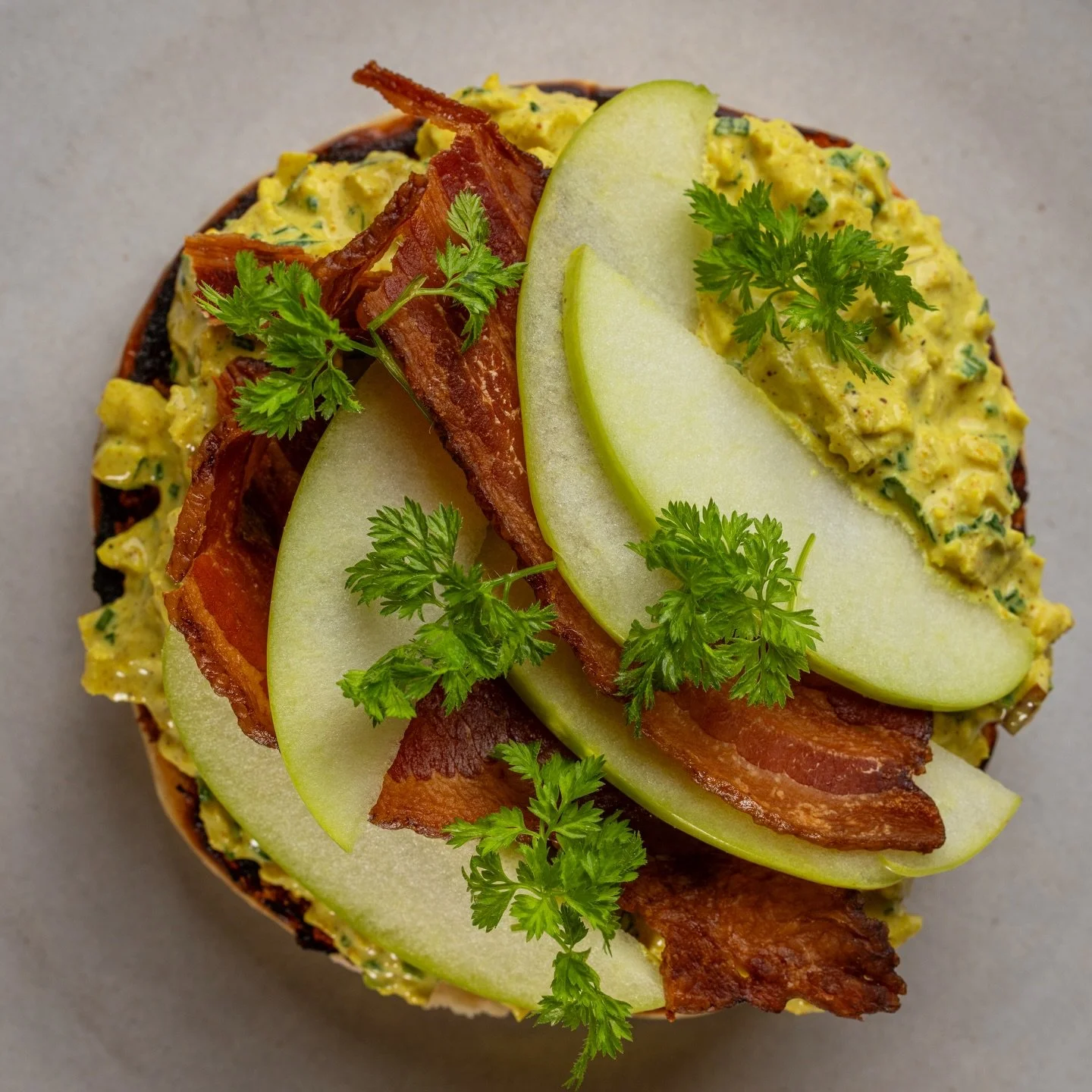 This is our curry chicken salad asking you to rethink lunch. Portuguese muffin, crispy bacon, green apple, chervil. Open-faced so you can see what you&rsquo;re getting into. Also available as a wrap with avocado if you&rsquo;re on the move.​​​​​​​​​​