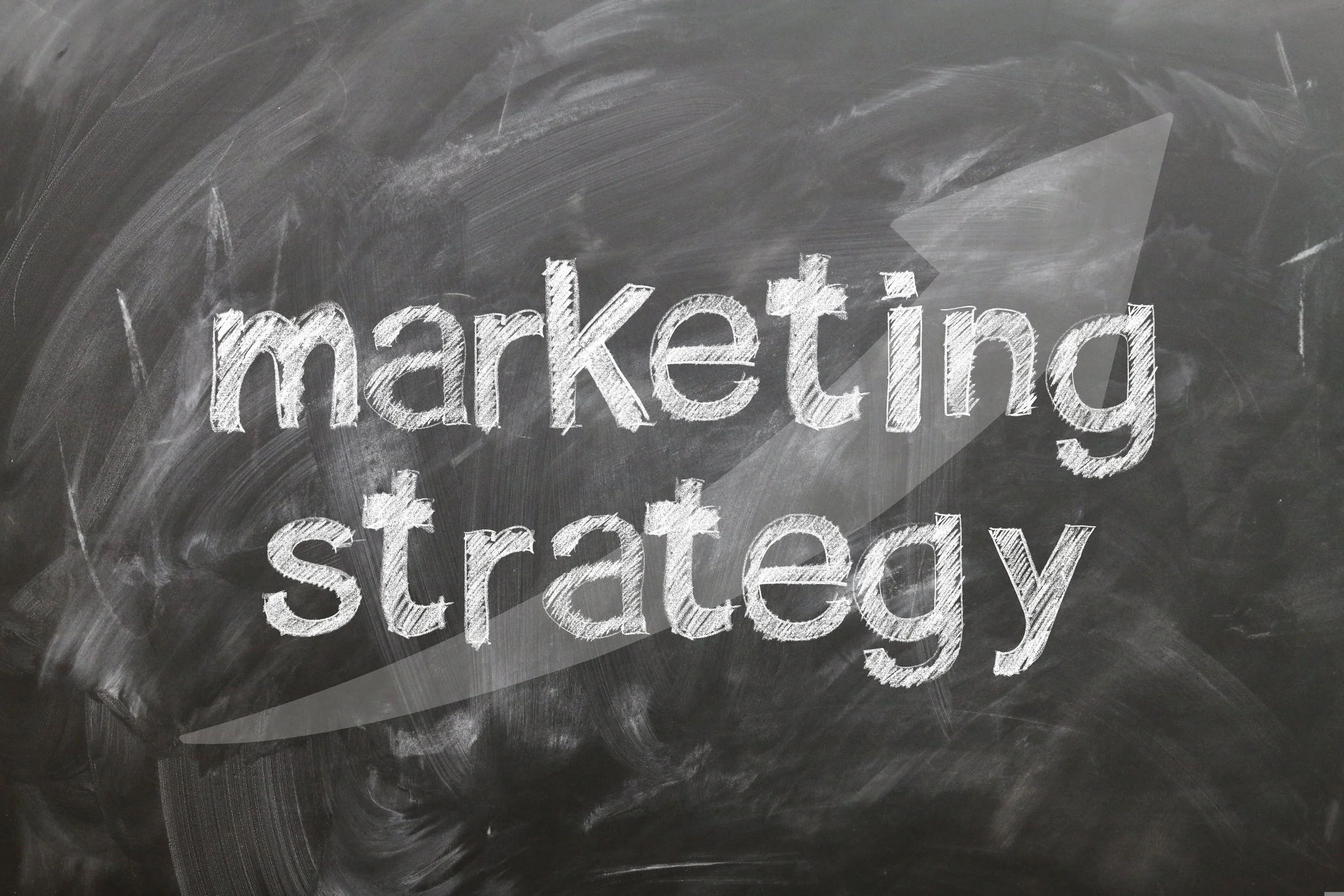 The words 'marketing strategy' written in chalk on a blackboard.