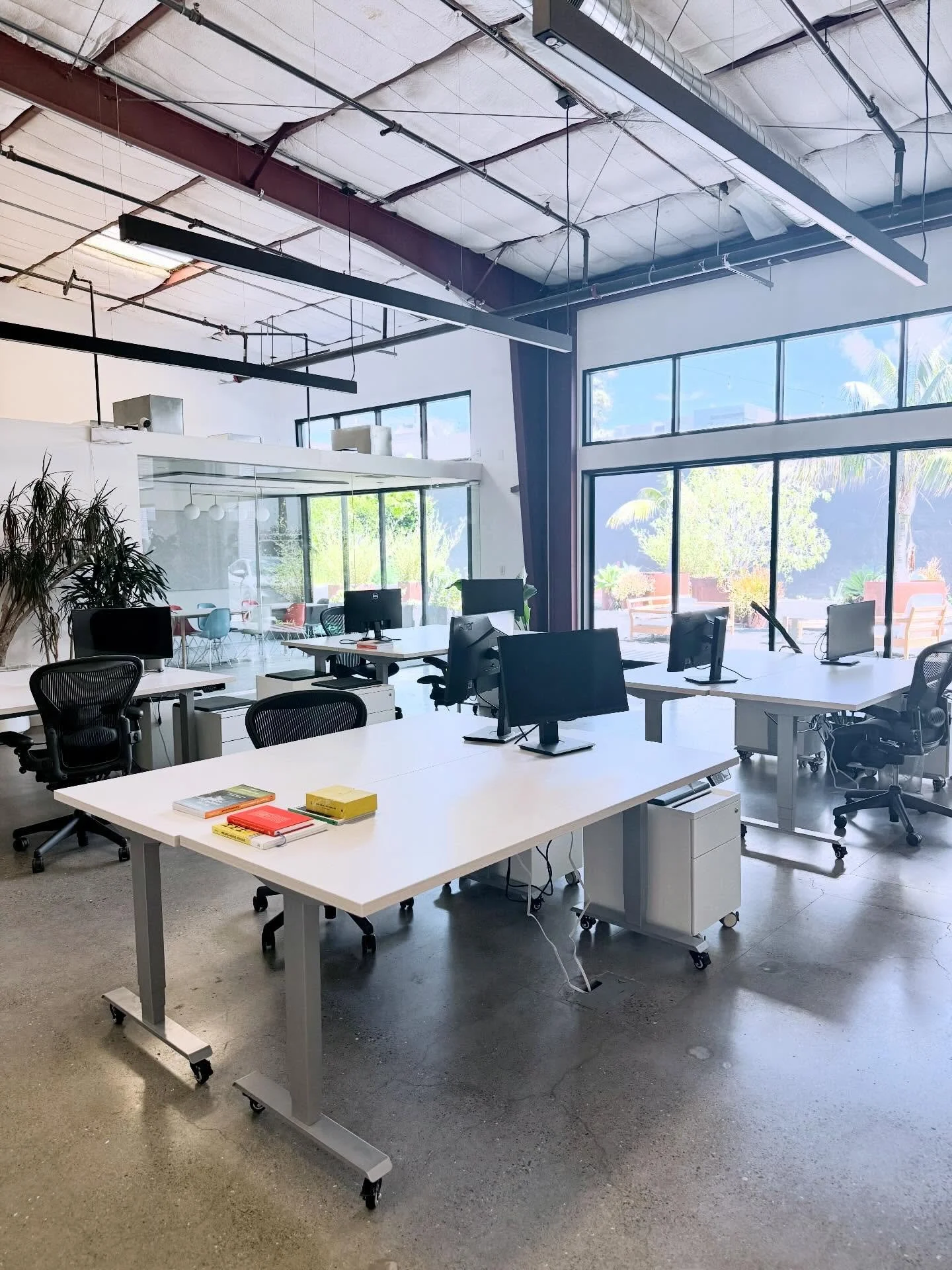 Dedicated stations with adjustable standing desks, monitors, filing cabinets and Aeron chairs.