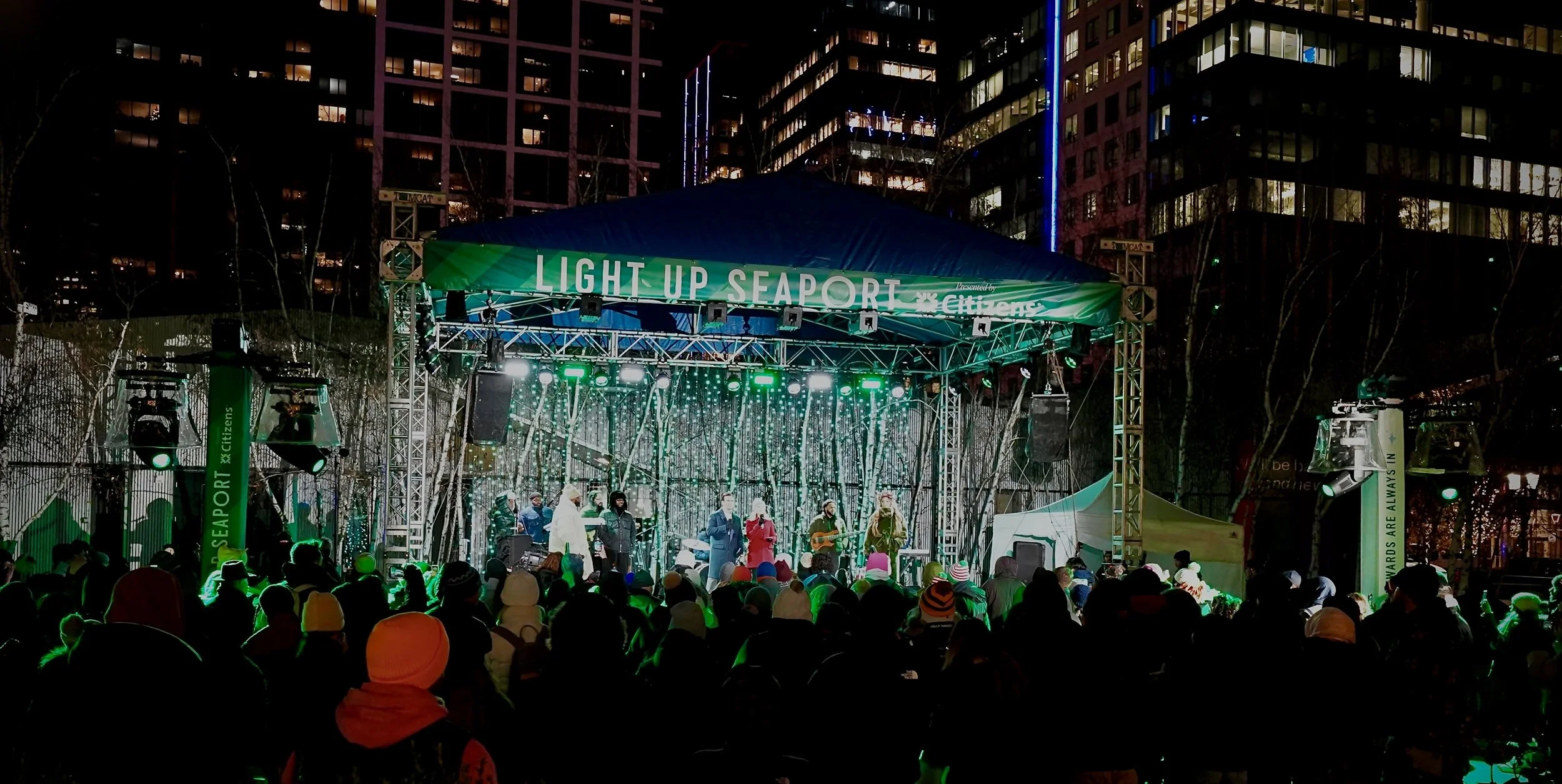 An outdoor concert at night on a stage with lighting, 'Light Up Seaport' HSP event production in Boston MA