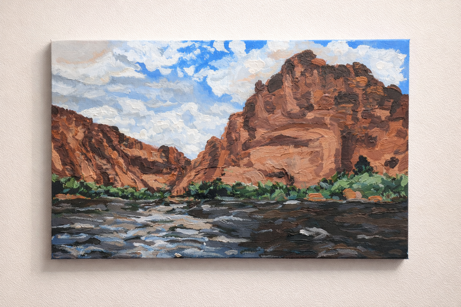 Painted landscape of a river flowing between red rock cliffs and a partly cloudy sky with trees along the riverbank.