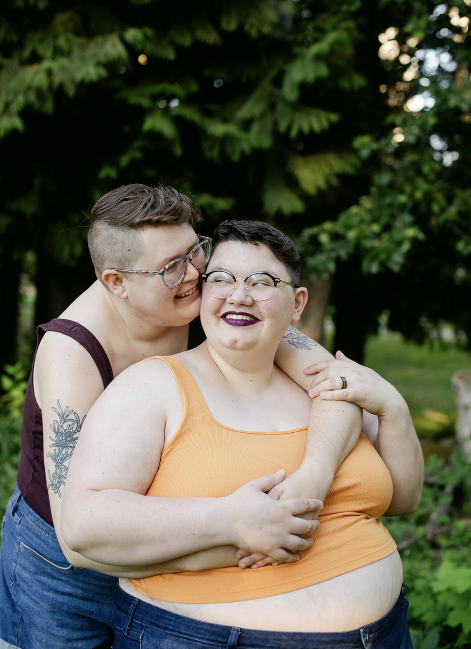 Smiling transgender couple embraced in a hug during engagement portrait session, authentic and inclusive LGBTQ+ wedding and engagement photography by Leah Flores of Wed n Wild, Portland Oregon